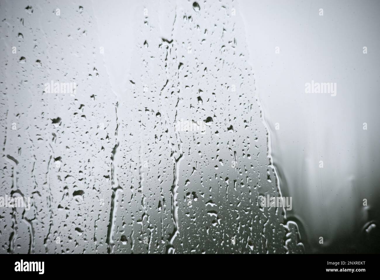 gocce di pioggia su un dolore della finestra in un giorno grigio piovoso Foto Stock