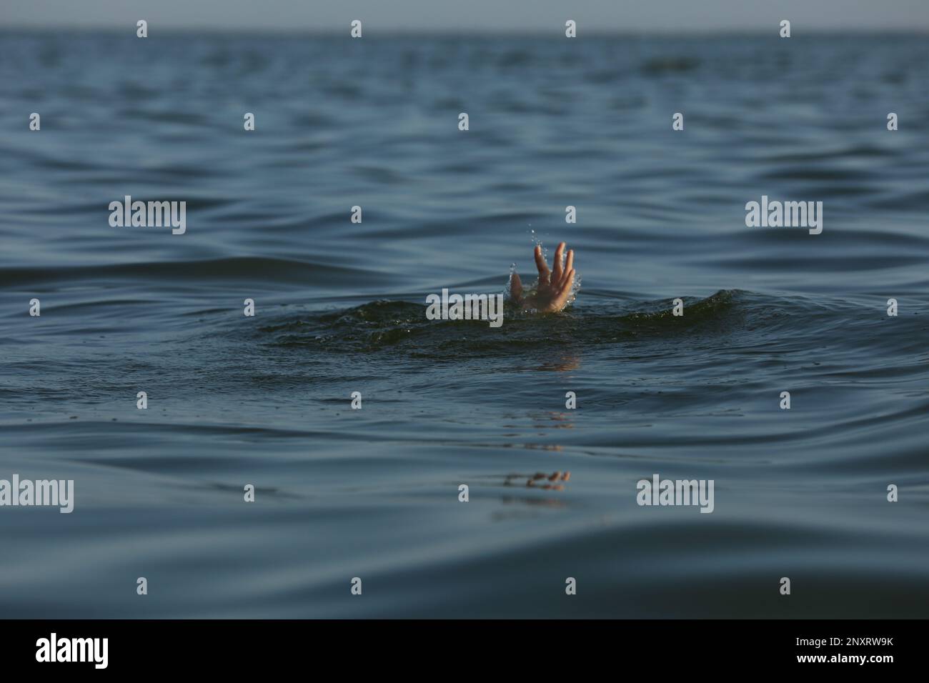 Annegando donna che raggiunge per aiuto in mare Foto Stock