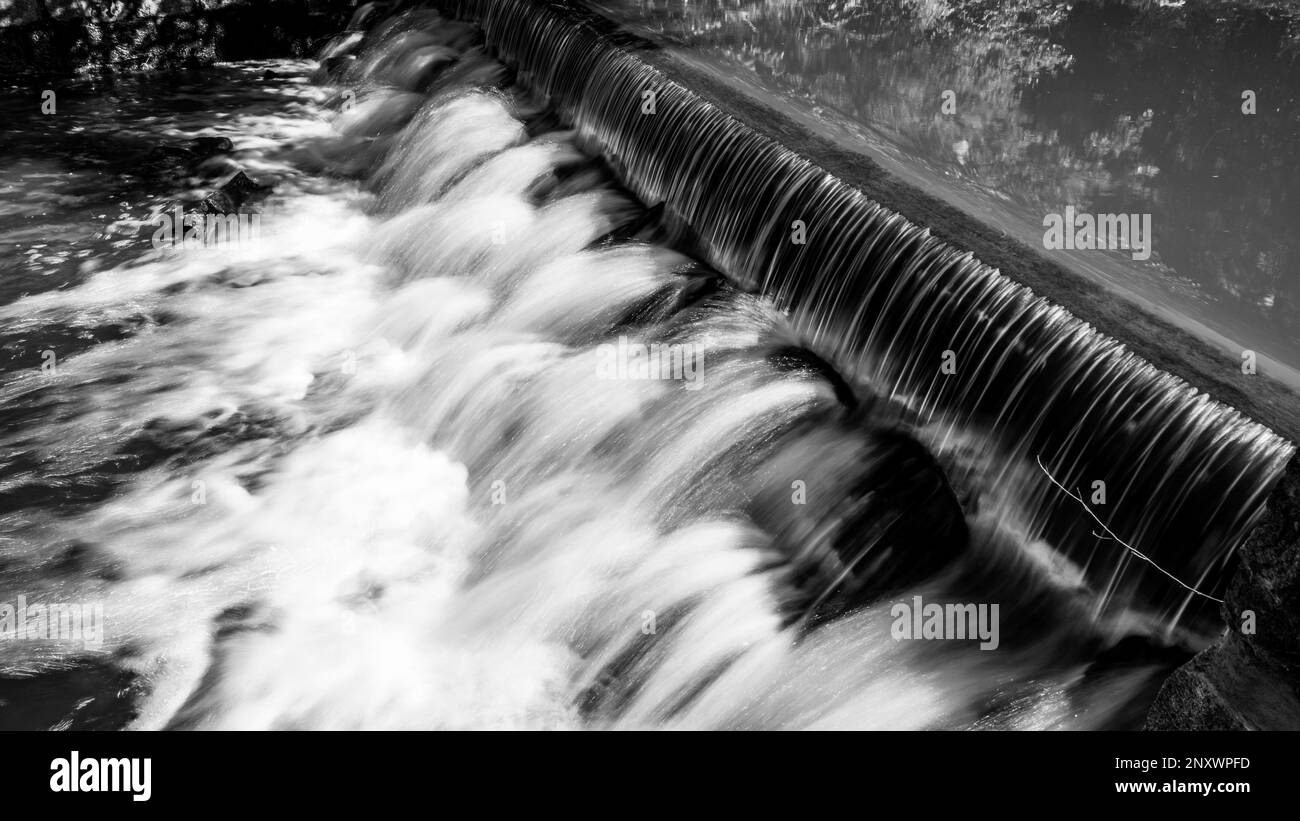 Piccola cascata sul torrente forestale. Gaden sluice pietra in tranquillo umore foresta. Immagine in bianco e nero. Foto Stock