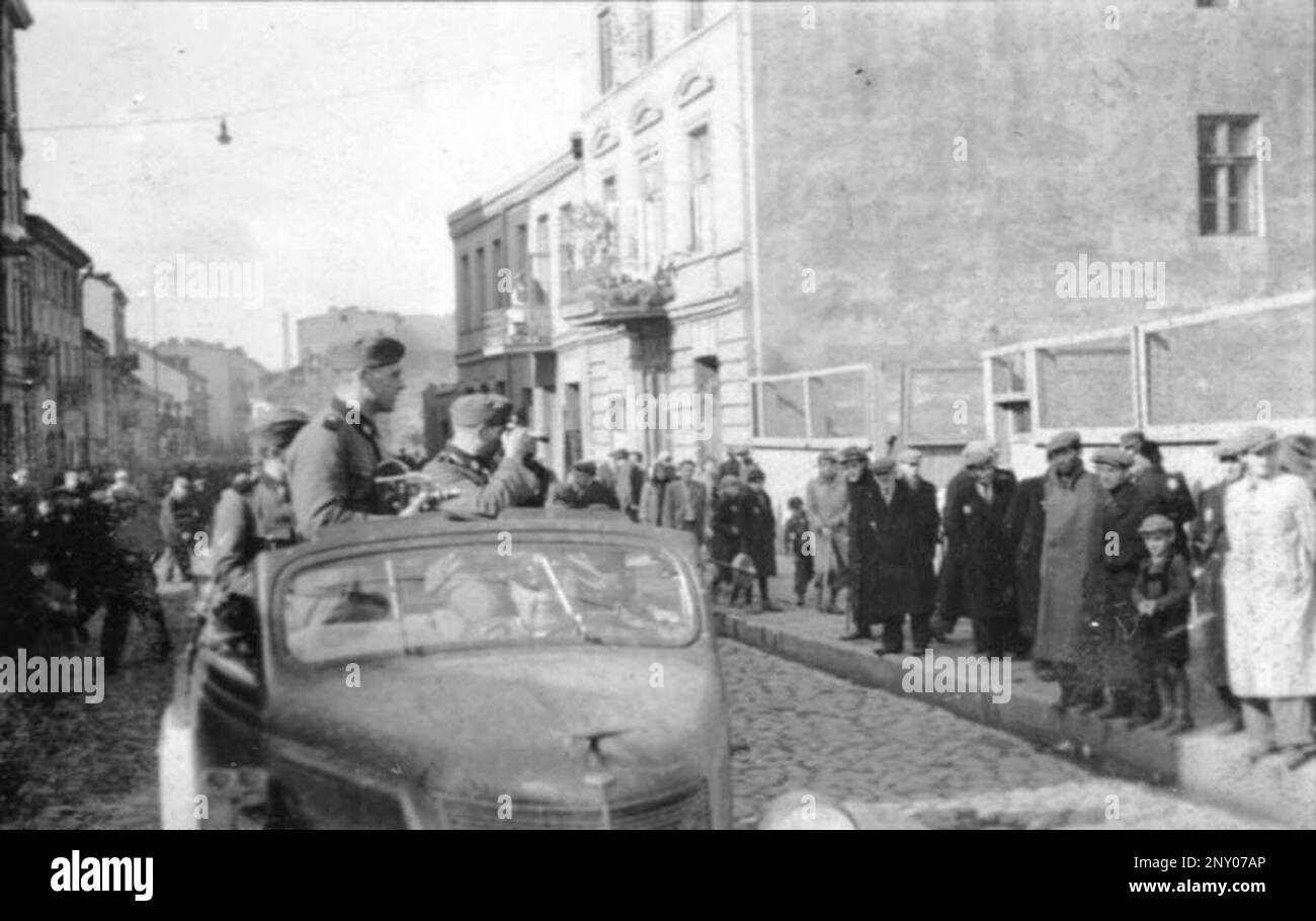Soldati della compagnia di propaganda Waffen-SS che guidano un'auto aperta, fotografando e filmando i residenti ebrei a Rauchgasse (via Wolborska) nel Ghetto Lodz. Bundesarchiv, Bild 101III-Schilf-002-14 / Schilf / CC-BY-SA 3,0 Foto Stock