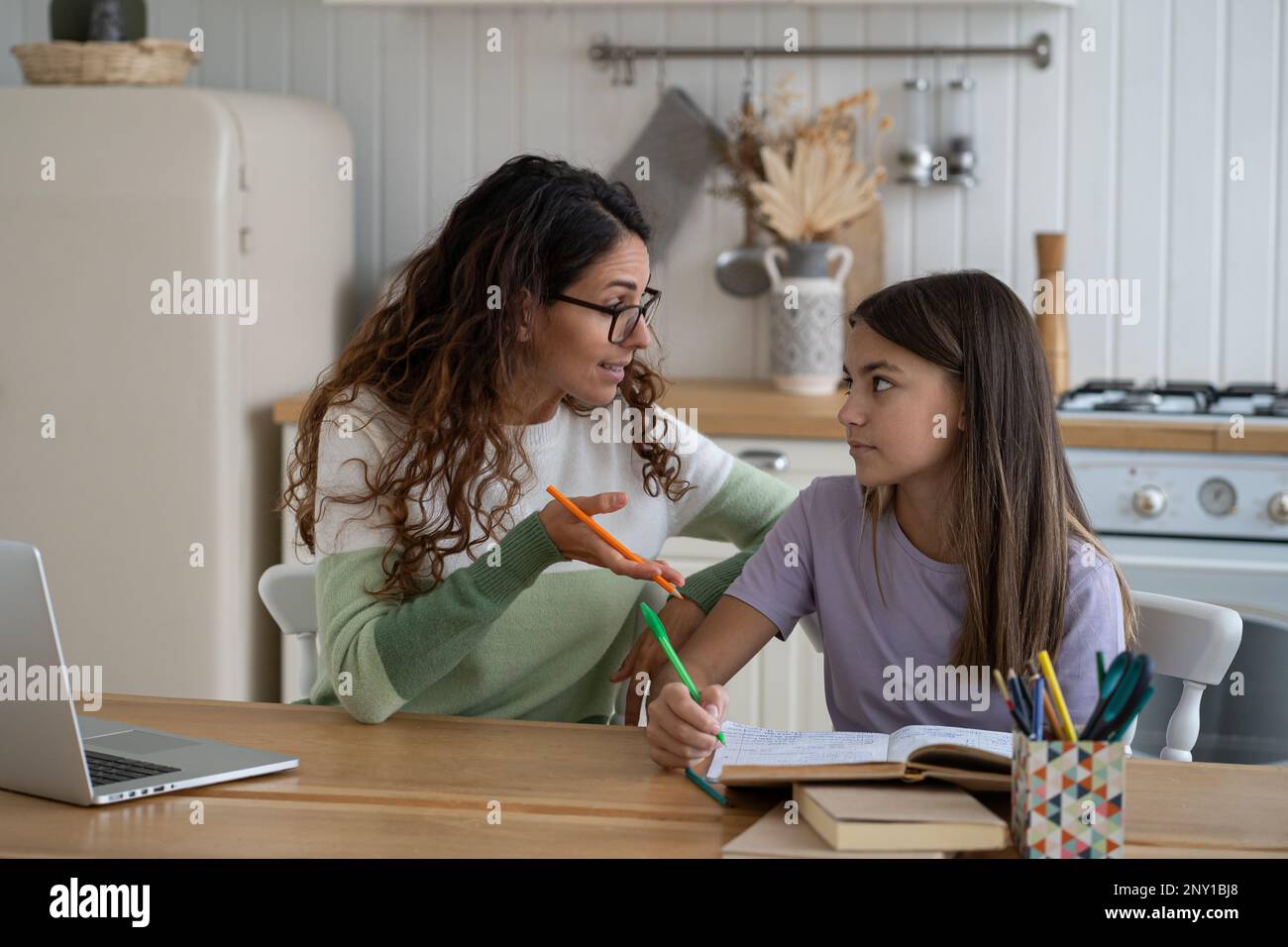 Insegnante confuso tutor donna in occhiali che studia con scolarista che si prepara per l'esame di prova a casa. Foto Stock