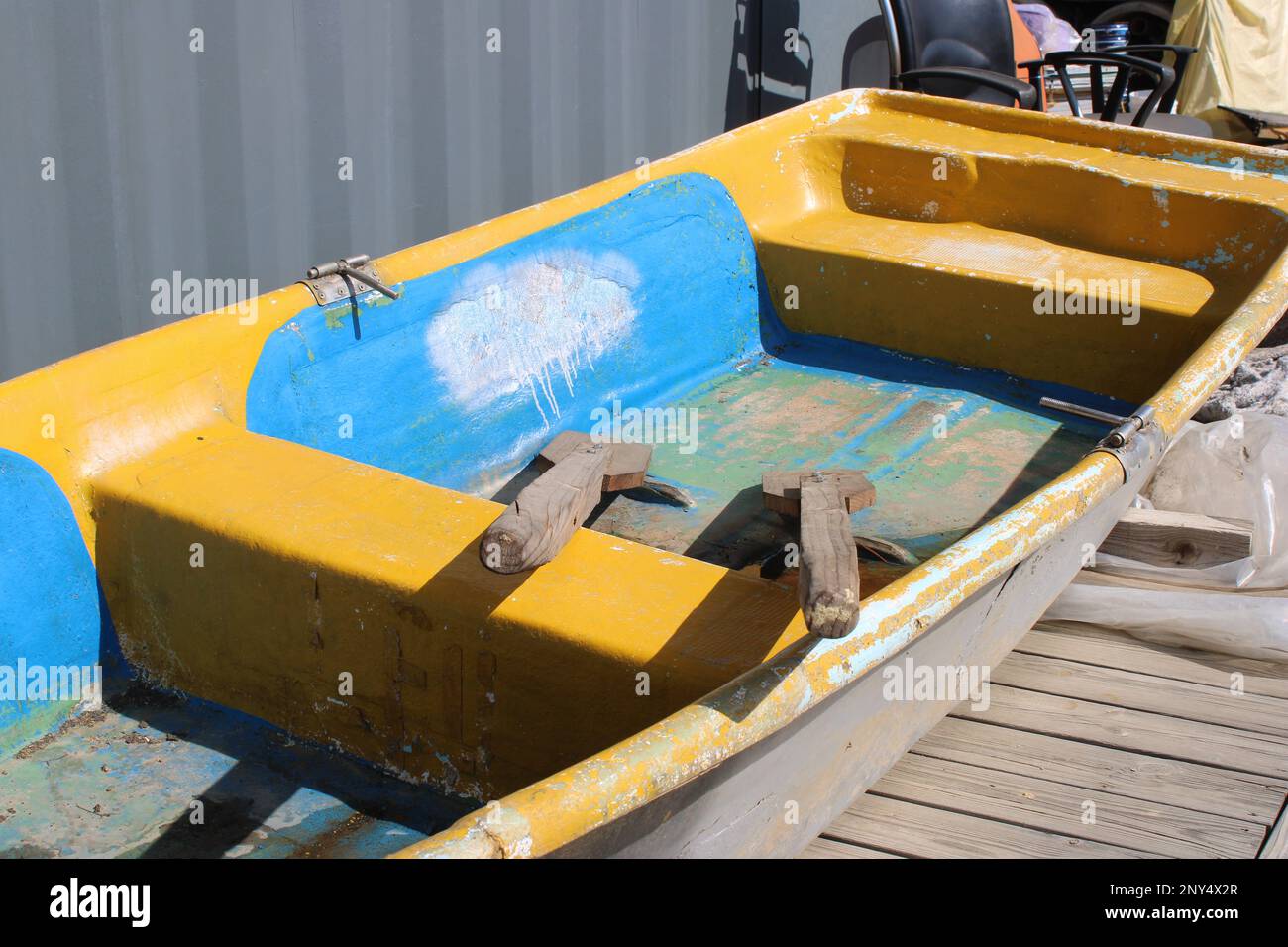 Imbarcazione a remi dipinta di blu e giallo in darsena Foto Stock