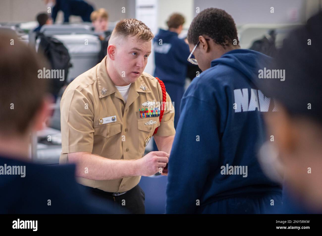 Equipment Operator 1st Class Richard Hall, di Sparta, Illinois, spiega come utilizzare un timbro per un comando di formazione reclutamento a bordo. Più di 40.000 reclute ogni anno si allenano presso l'unico campo di stivali della Marina. Foto Stock