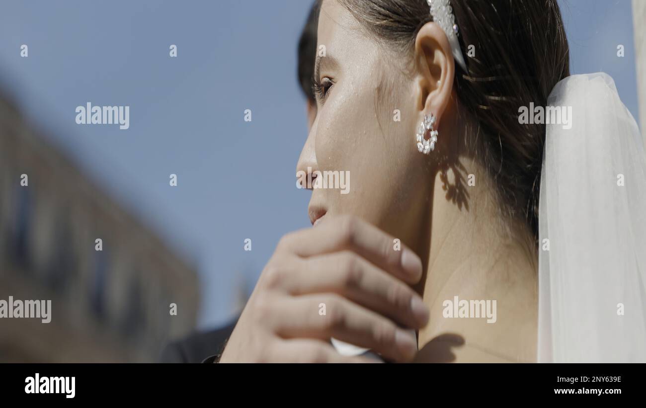 Abbracciare la sposa e lo sposo. Azione. Una coppia sorridente felice che si basa su un appuntamento all'aperto. Riprese in 4K di alta qualità Foto Stock