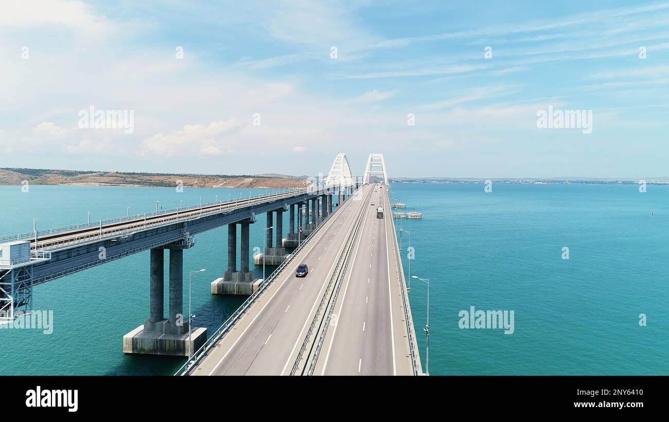 Vista dall'alto del bellissimo ponte sul mare blu. Scatto. Lunga autostrada con ponte sull'acqua blu. Ponte attraverso stretto tra le isole con bella stagione Foto Stock