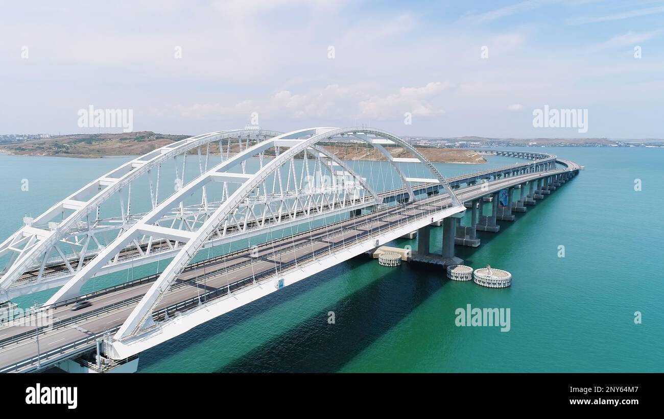 Vista dall'alto del bellissimo ponte sul mare blu. Scatto. Lunga autostrada con ponte sull'acqua blu. Ponte attraverso stretto tra le isole con bella stagione Foto Stock