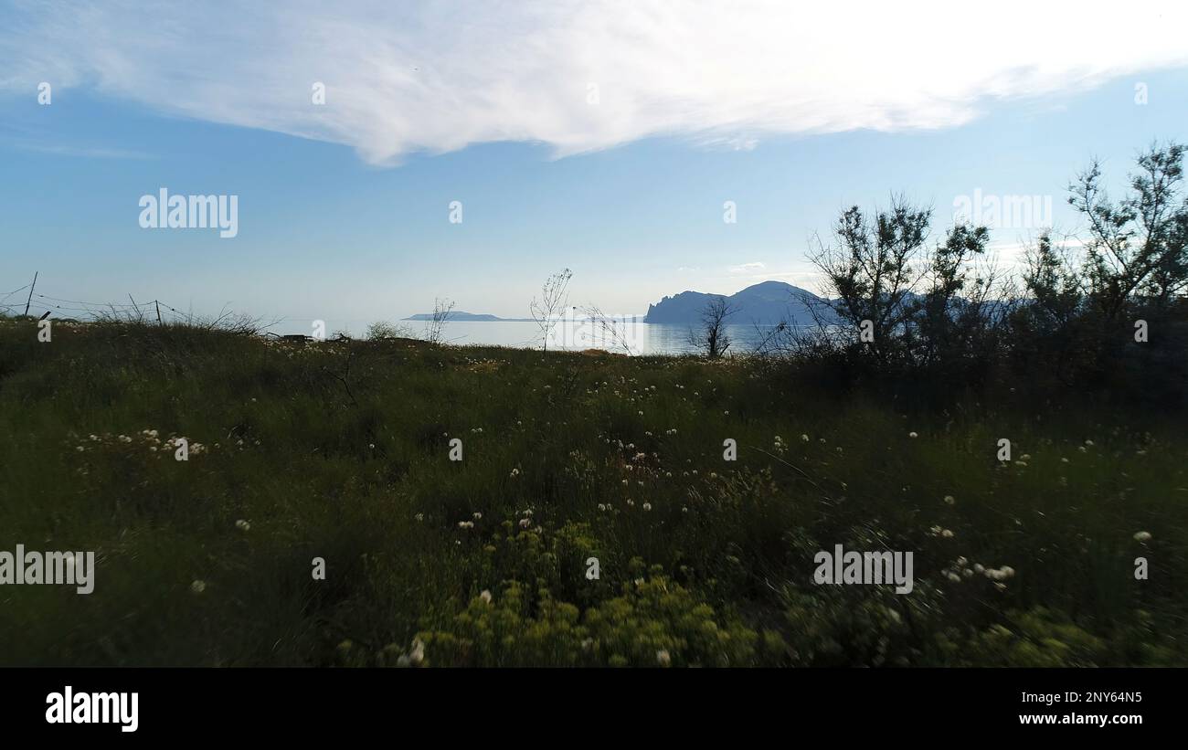 Splendida vista sulla costa con erba sullo sfondo di rocce e mare. Scatto. Il drone si muove sull'erba con vista sul mare e sull'orizzonte. Bella panoramica vi Foto Stock