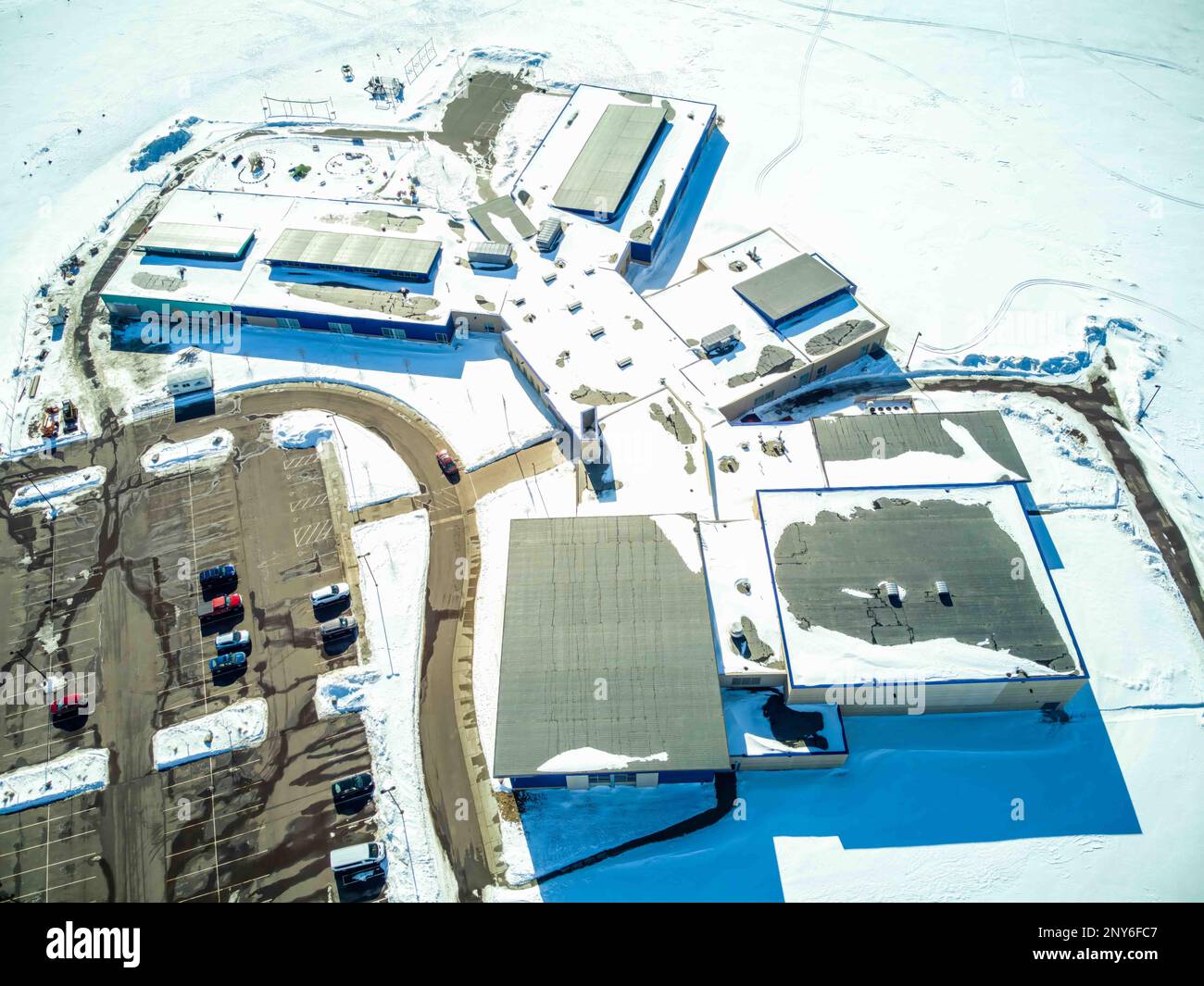 Vista sopraelevata del drone di un edificio con tetto piatto con unità di ventilazione e carico di neve. Foto Stock