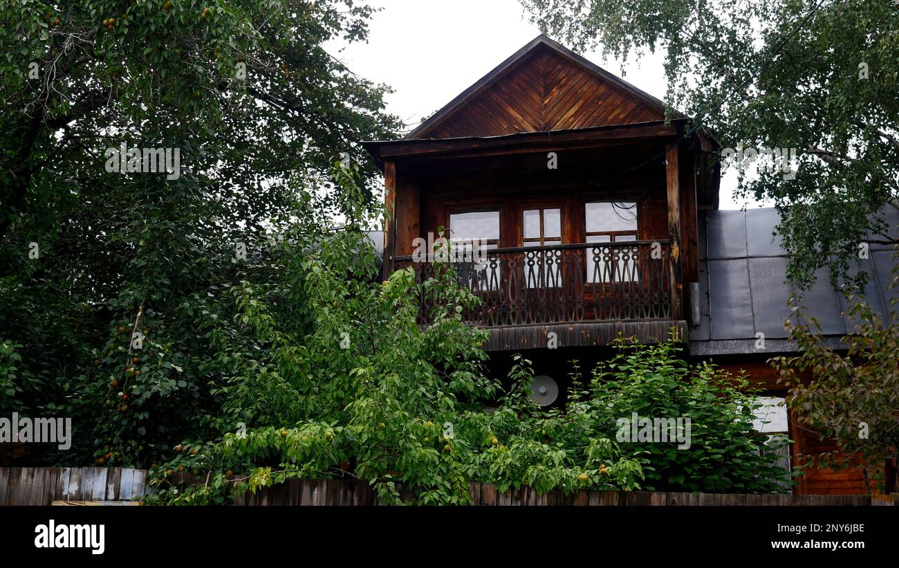 Una casa di campagna fuori città. Stock footage.A calma, luogo tranquillo con un giardino costruito e una piccola casa di legno sullo sfondo di vegetazione crescente Foto Stock