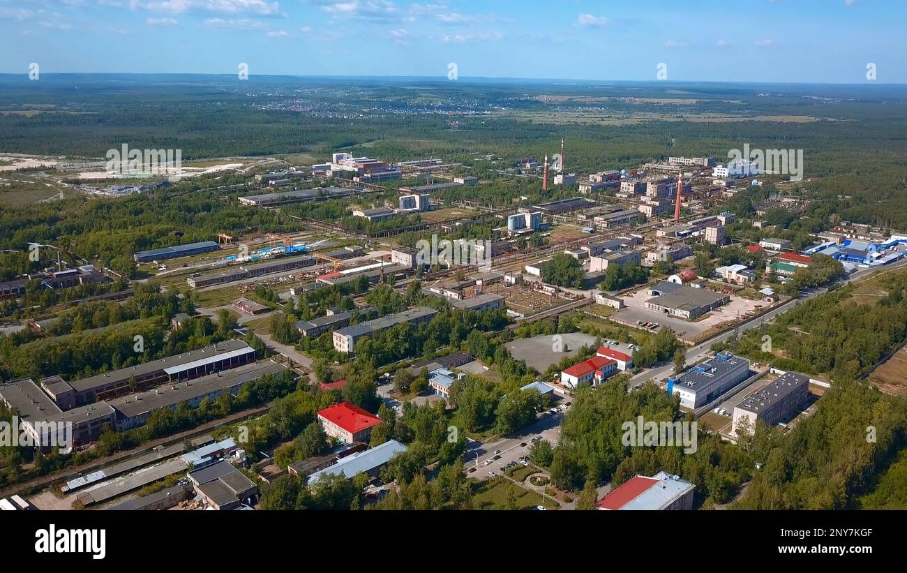 Vista aerea degli edifici industriali nel sobborgo della città, vicino alla foresta e alla natura. Clip zona industriale di una città Foto Stock