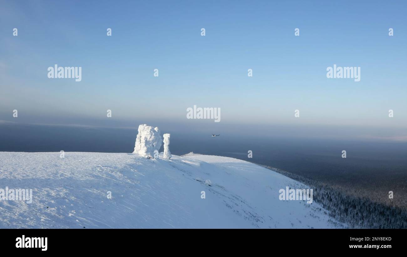 Veduta aerea invernale dei giganti dell'altopiano di Manpupuner, Repubblica di Komi. Fermo. Elicottero che vola sopra le colline innevate Foto Stock