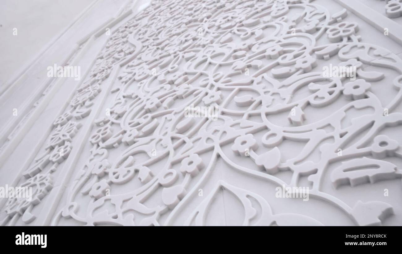 Elemento decorativo in intonaco bianco sulla parete. Scenografia. Bellissimo ornamento e rilievo all'interno dell'edificio Foto Stock