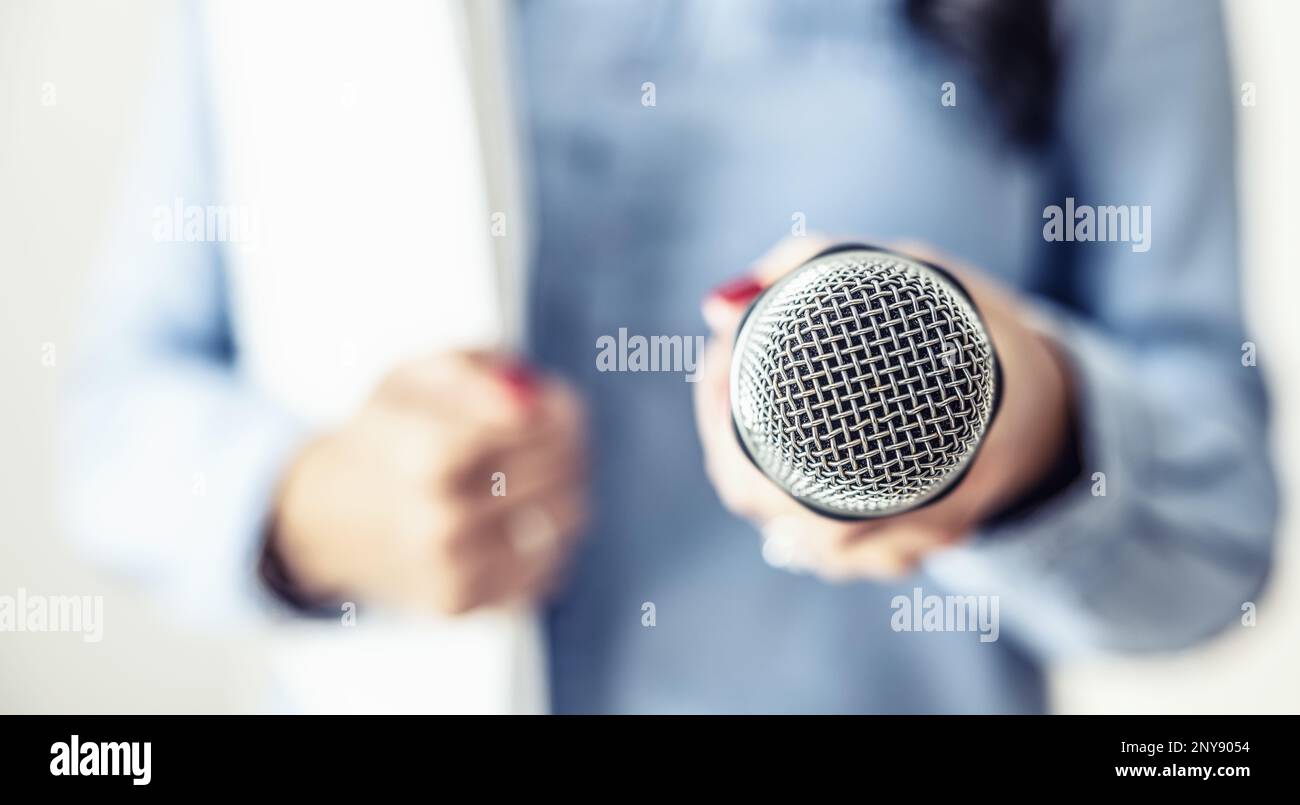 Giornalista di sesso femminile in una conferenza stampa con microfono e notebook. Foto Stock