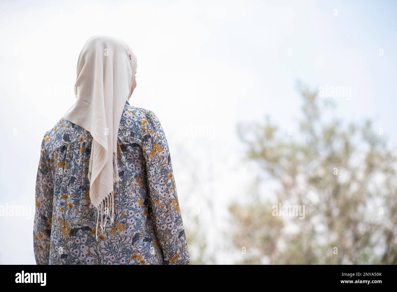 Vista posteriore di una donna musulmana che indossa un hijab in piedi all'aperto Foto Stock