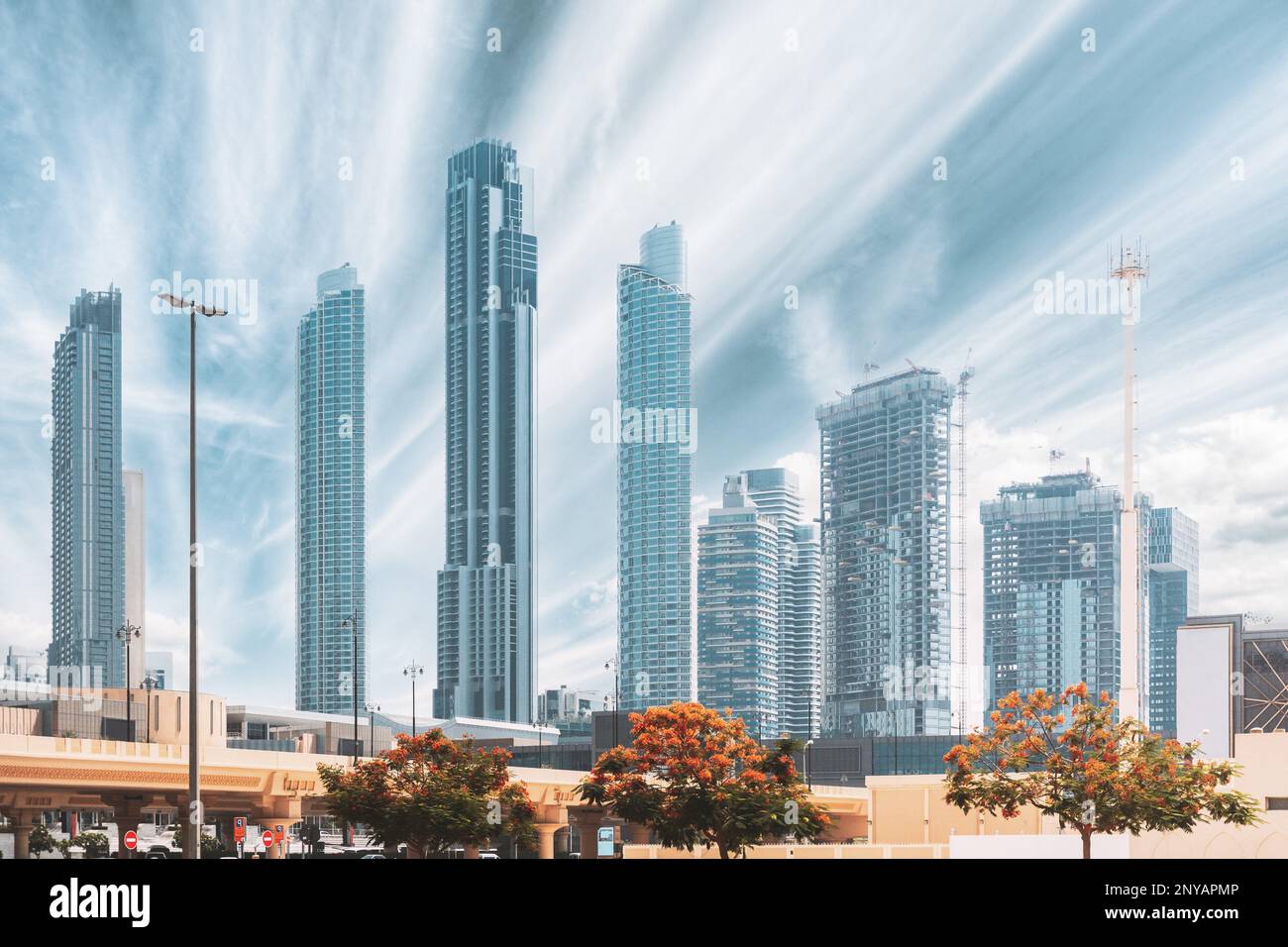 La gru da cantiere è impegnata nello sviluppo di un nuovo edificio residenziale a più piani. Vista dei moderni grattacieli di Dubai. Sviluppo delle costruzioni Foto Stock