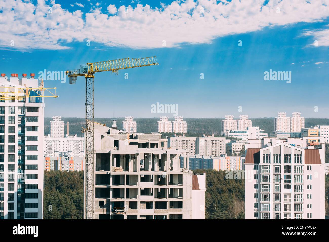 Nuovo concetto di alloggio. Incredibile cielo blu brillante sopra la gru da cantiere. Costruzione e sviluppo di nuovi edifici residenziali a più piani. Concezione Foto Stock