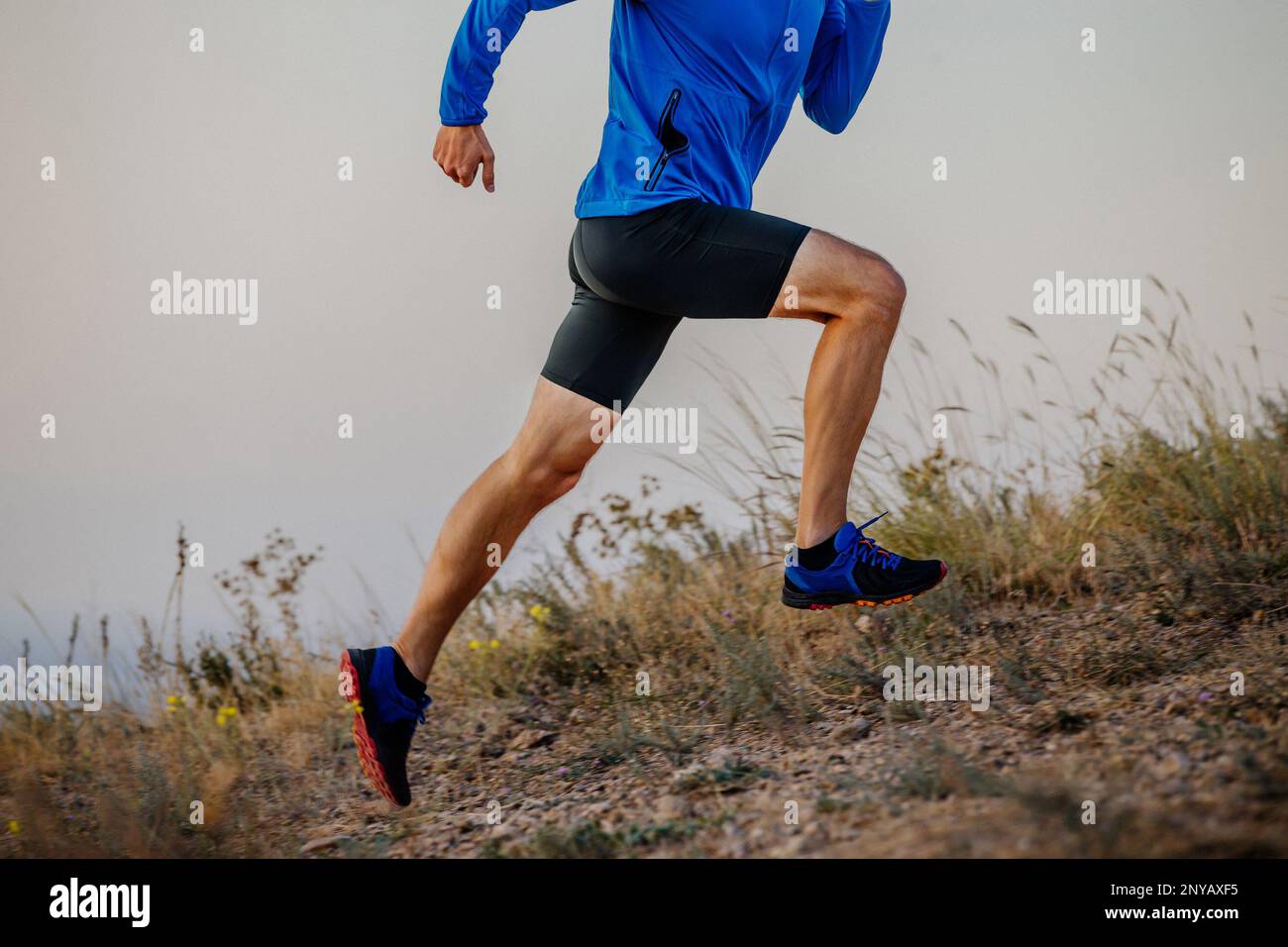 gambe maschio runner che corre su sentiero di montagna Foto Stock