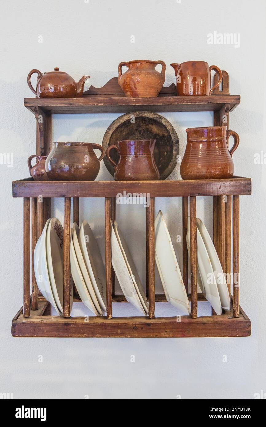 Vecchio piatto rack di legno pieno di ceramica. Cottage cucina concetto. Foto Stock