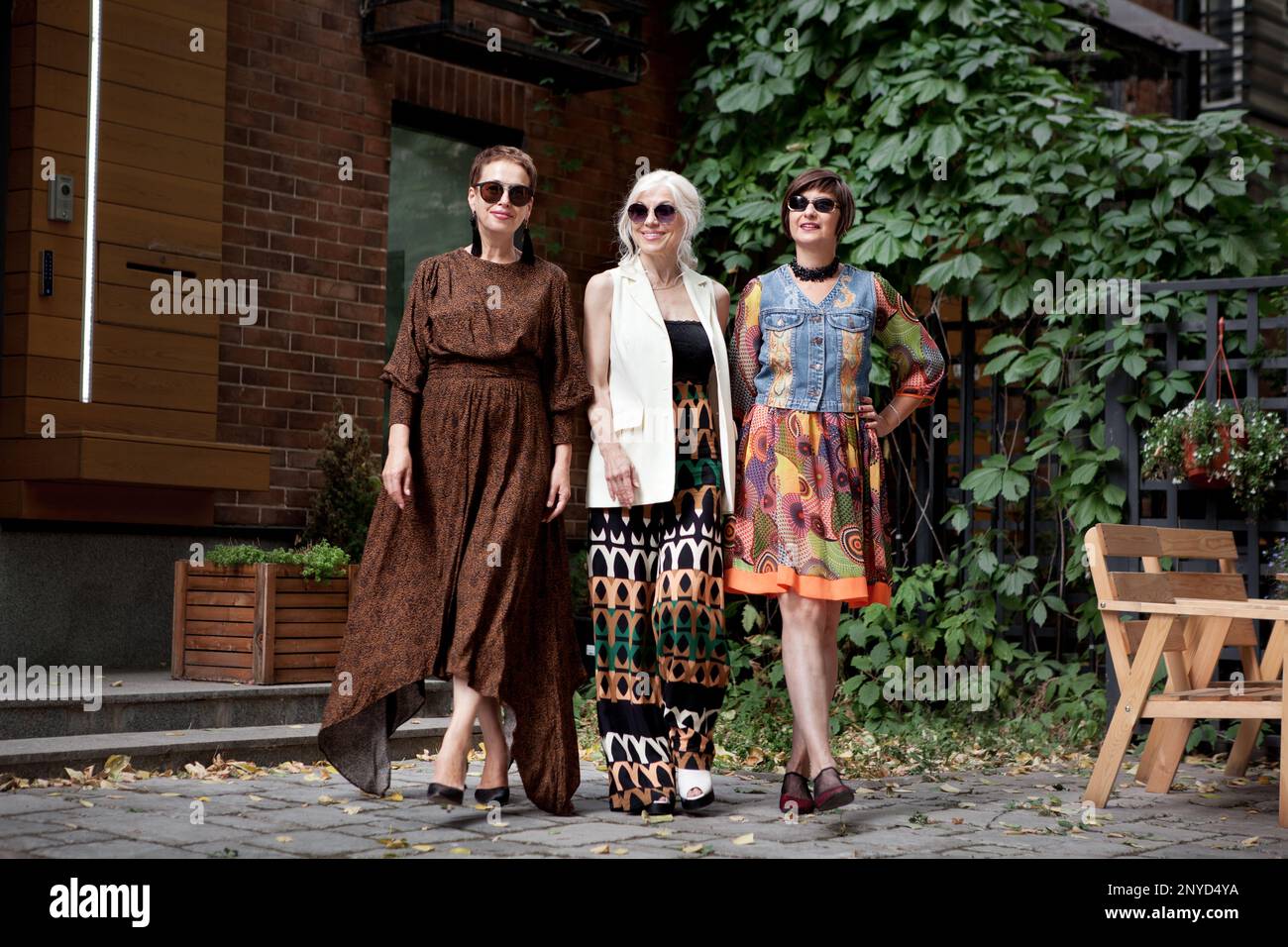 Belle donne di mezza età che camminano per la strada cittadina. Modelli di moda anziani che indossano abiti eleganti. Stile Street. Donna matura amici godendo la vita Foto Stock