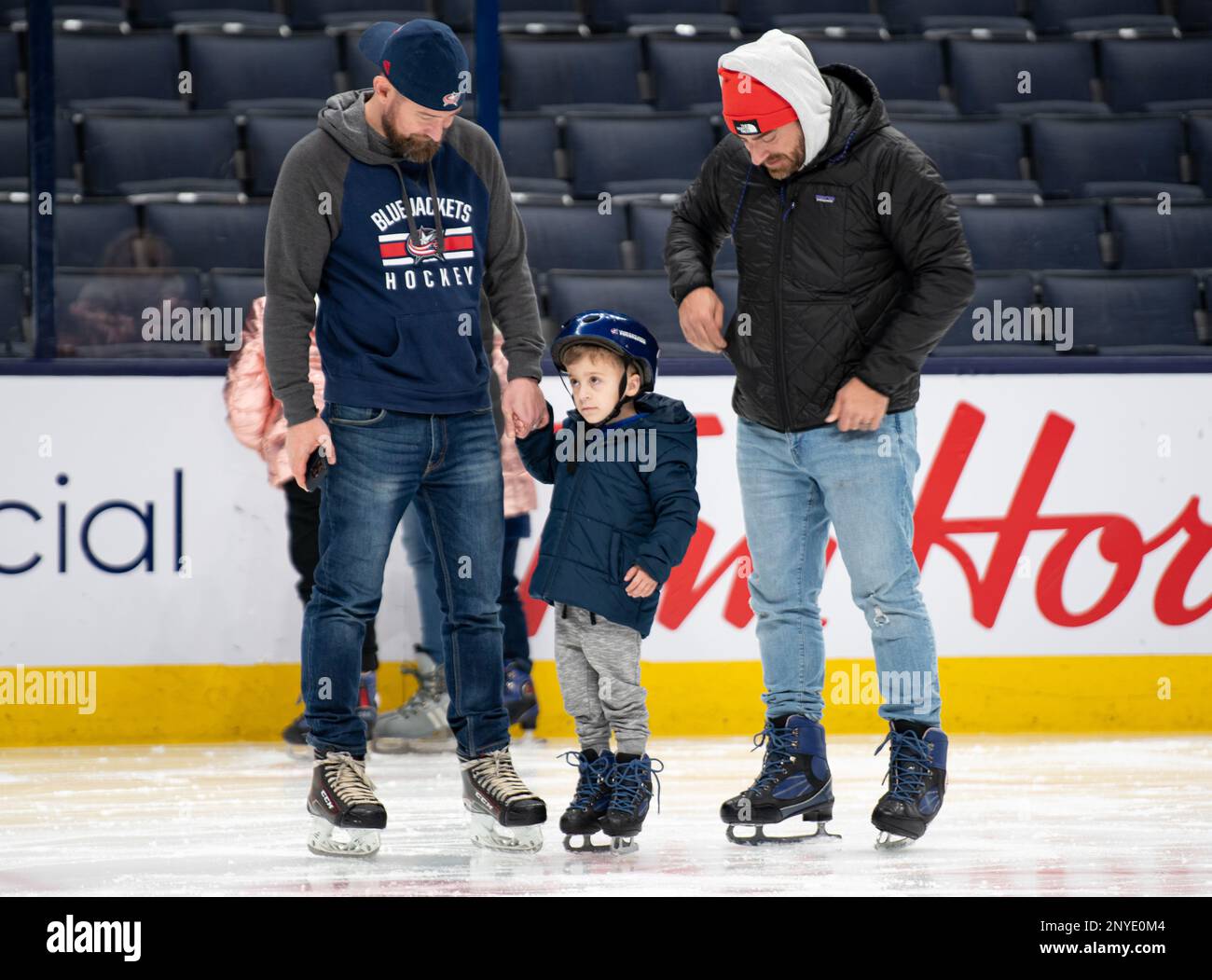 Donnie Moncrief (a sinistra), un giocatore dei Wright Flyers, è affiancato dal cugino Michael Surace (a destra) e dal figlio di Surace, Luca, sul ghiaccio il 5 gennaio 2023, alla Nationwide Arena di Columbus, Ohio. Nell'ambito della serata annuale Military Appreciation Night, gli ex giocatori di Columbus Blue Jackets hanno affrontato la scena in un'amichevole mostra contro i Wright Flyers, un club ricreativo composto da personale militare e civile della base dell'aeronautica militare Wright-Patterson. Foto Stock