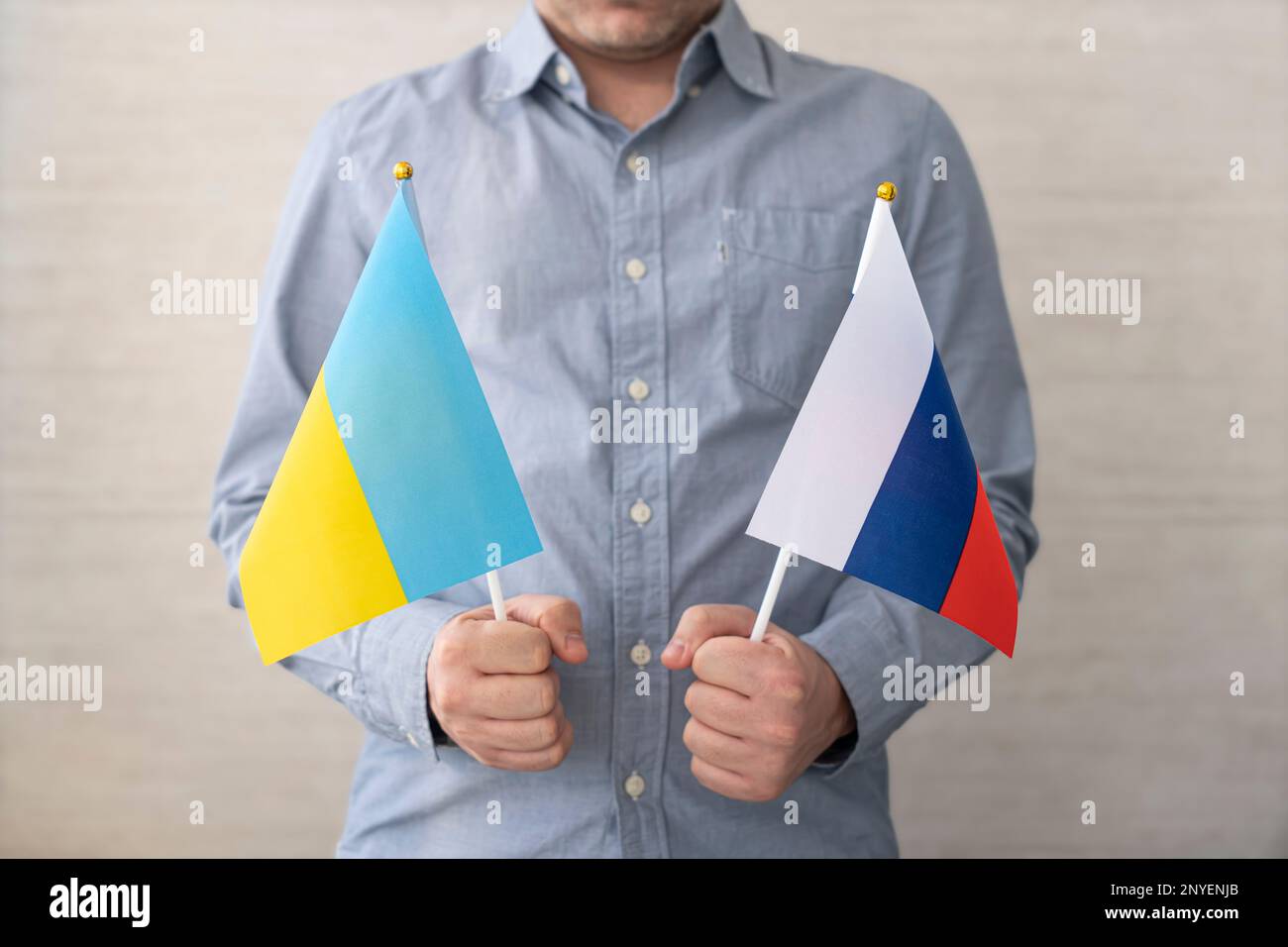 Un uomo tiene in mano due bandiere russe e ucraine. Il concetto di scelta in un referendum. Foto Stock