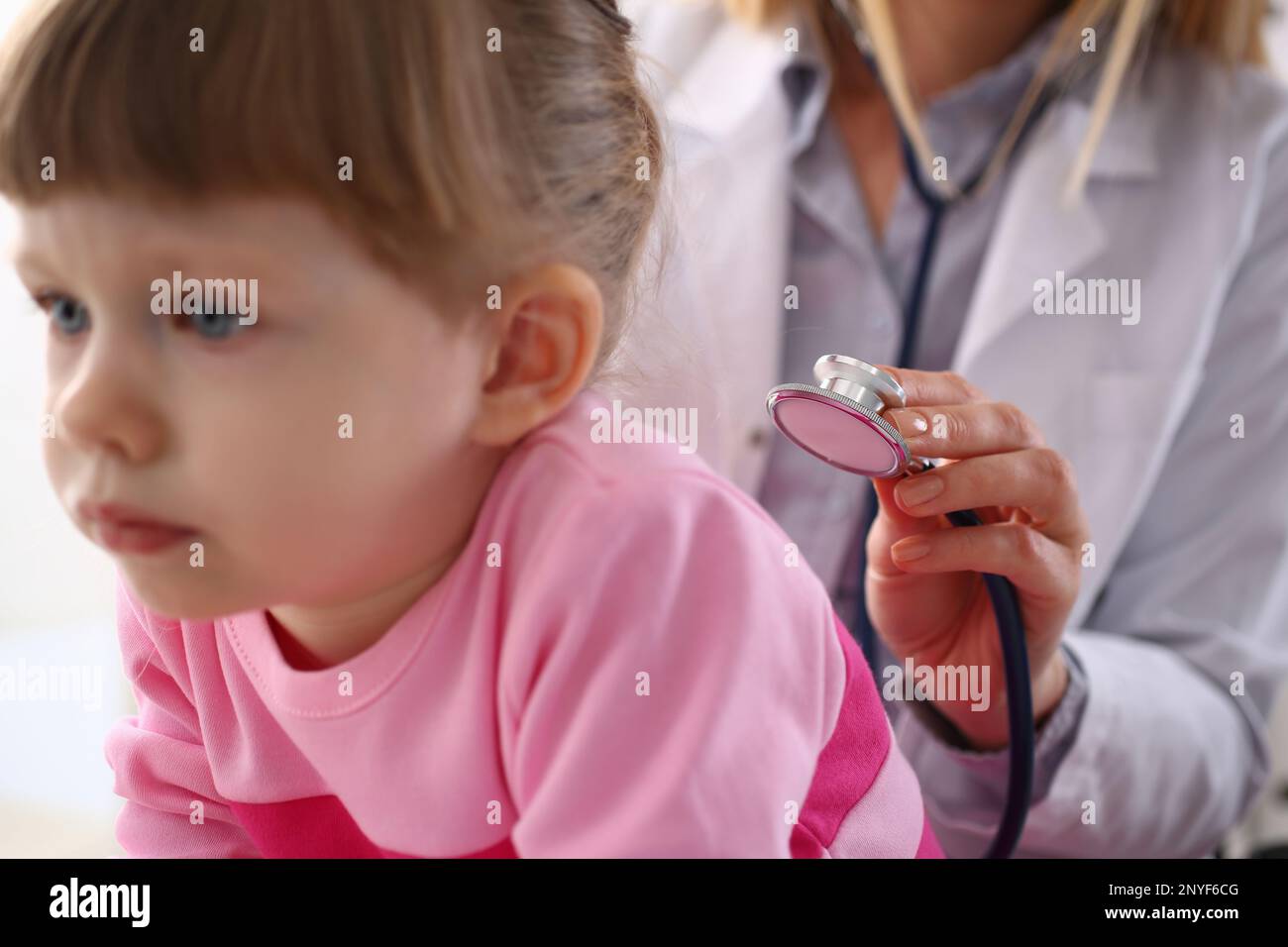 Pediatra ascolta i polmoni della bambina con stetoscopio Foto Stock