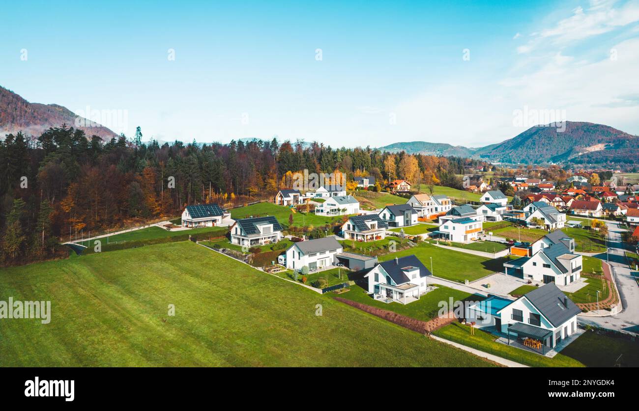 Vita nei sobborghi, nuove case costruite dalla foresta con un sacco di campi verdi tutto intorno Foto Stock