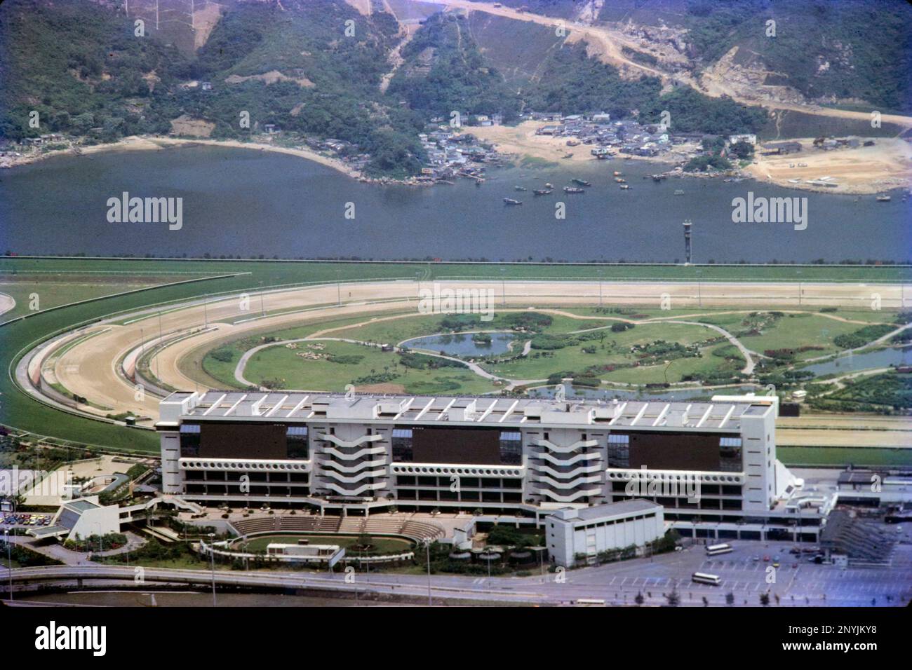 Vista paesaggistica della Grandstand all'Ippodromo di Shatin, da Kau a Shan, Shatin, New Territories, Hong Kong, nel 1980. Il fiume Shing Mun e le pendici inferiori di ma on Shan (ora ma on Shan New Town) alle spalle. Foto Stock