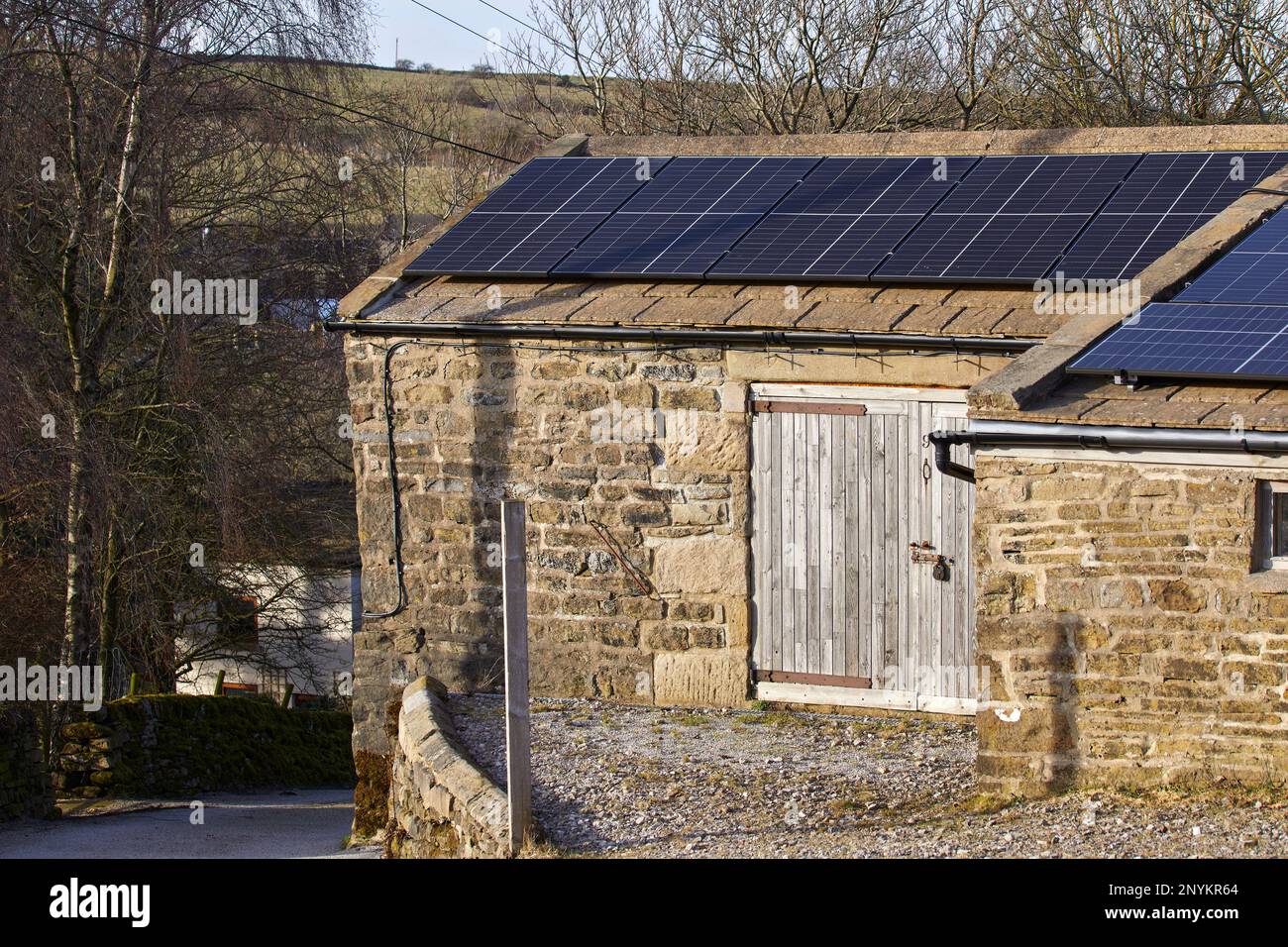 Febbraio sole cattura il pannello solare istituito sul tetto fienile fattoria sul North Yorkshire piccola holding a 900ft Foto Stock