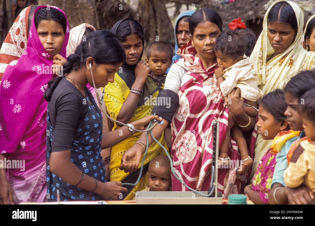 India, Tamil Nadu. Un'infermiera sta assumendo la pressione sanguigna di una donna. Foto Stock