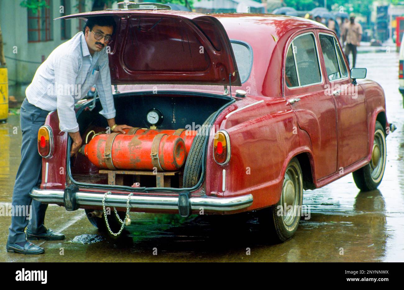 India, l'uomo sta testando serbatoi di gas nella sua macchina indiana Tata. Foto Stock