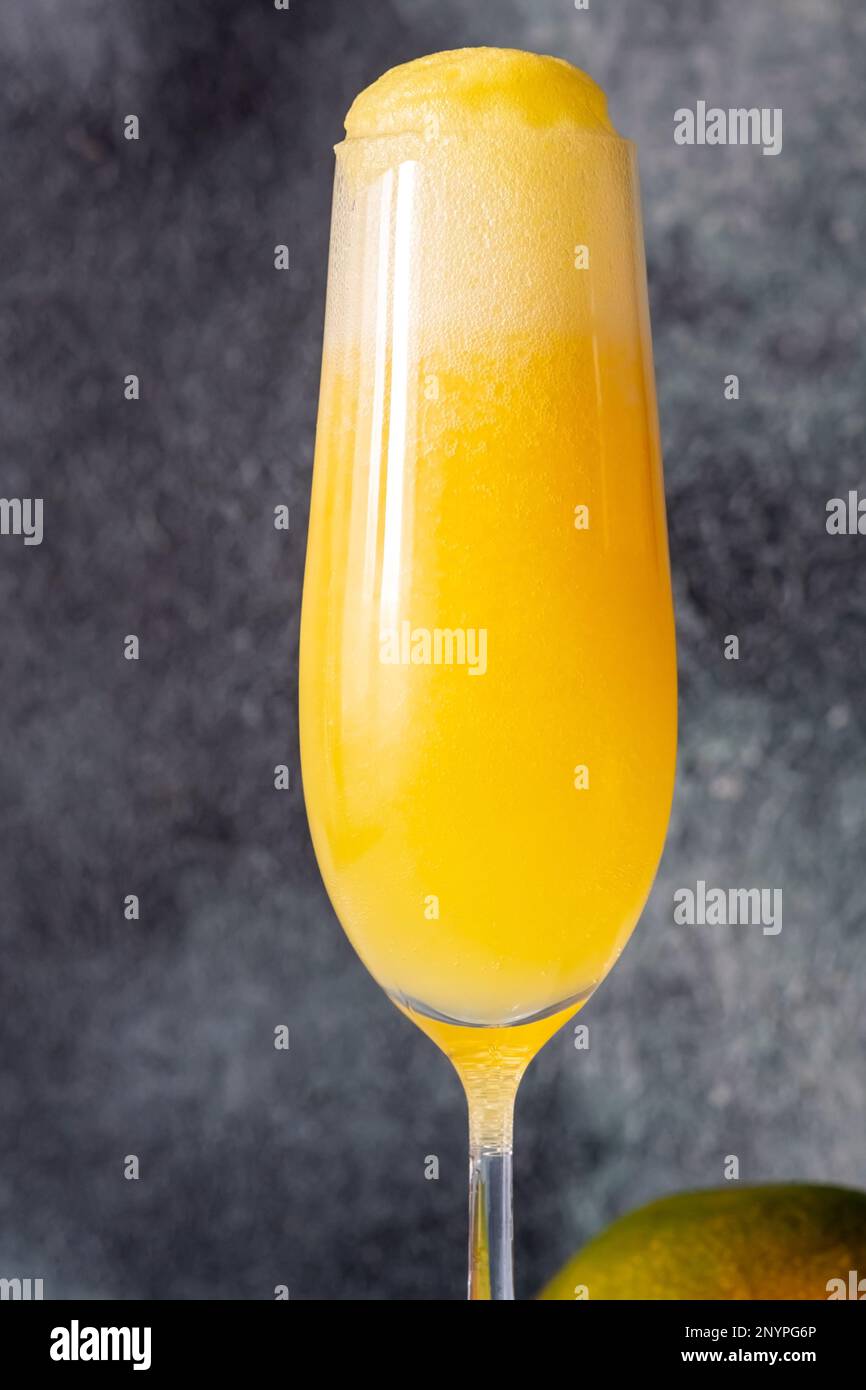 Flauto bicchiere di Mango Mimosa cocktail su sfondo grigio Foto Stock