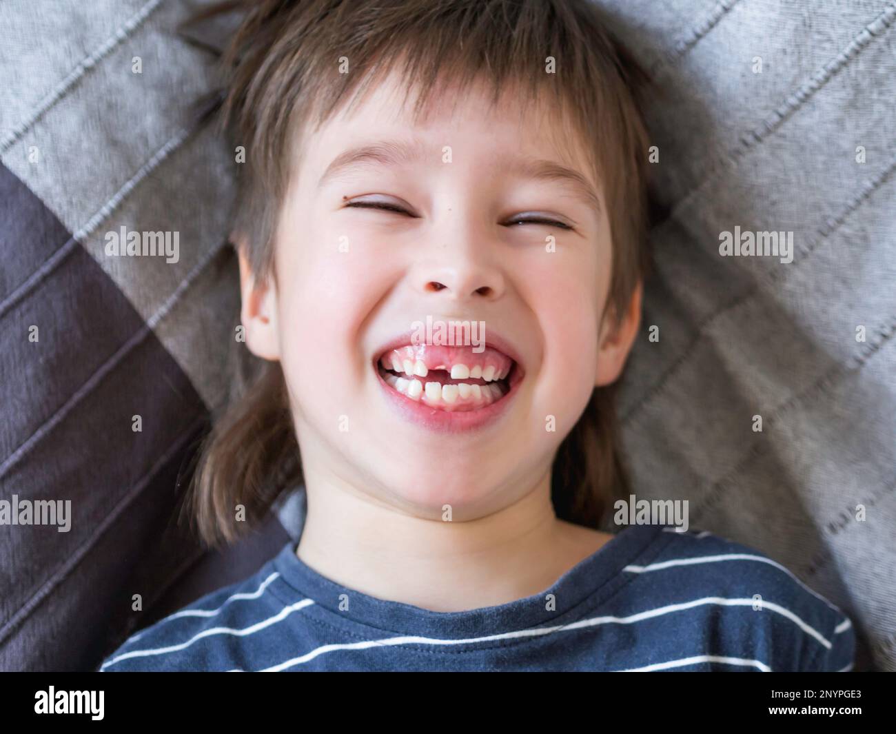 Ridendo bambino mostra buco in fila di denti in bocca. Un incisor è caduto fuori appena ora. Primo piano foto gengive per dentista. Foto Stock