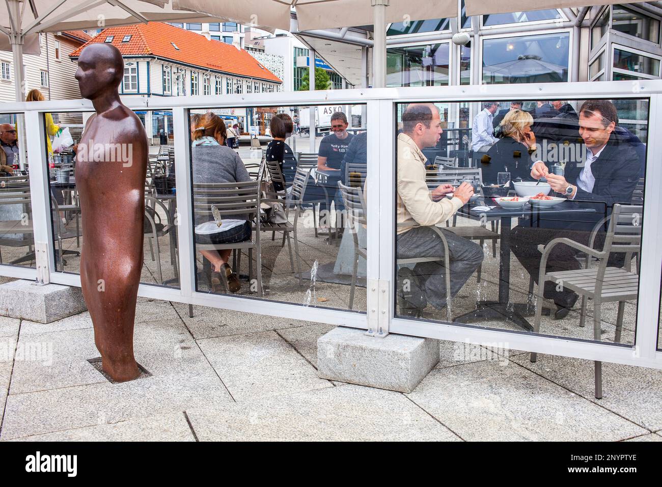 Terrazza del mercato ristorante di pesce e la scultura di Antony Gormley (colonna spezzata), in porto Vagen,Stavanger, Norvegia Foto Stock