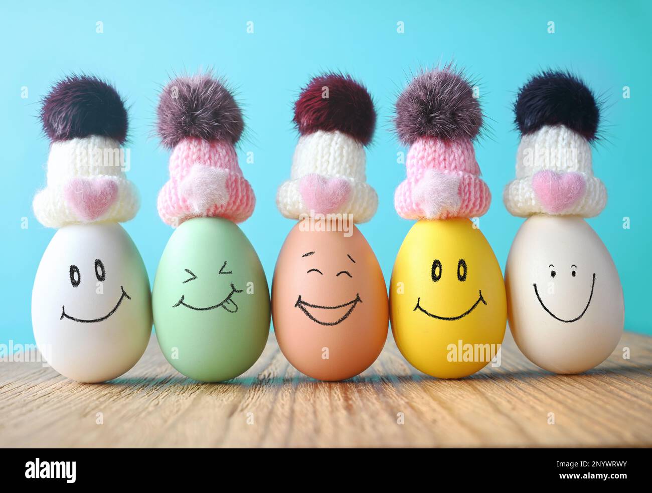 Uova felici in cappelli ridendo. Concetto di vacanza di Pasqua con le uova carine con i volti divertenti Foto Stock