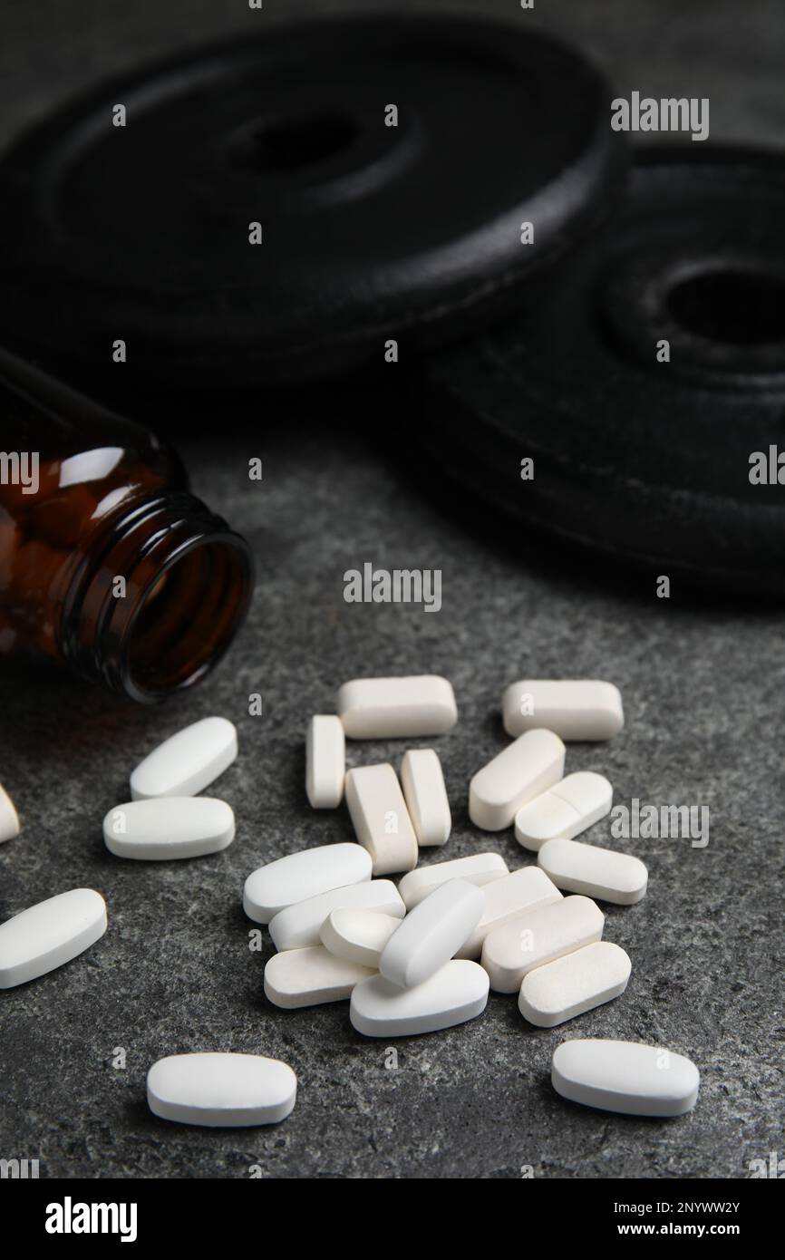 Flacone e pillole di aminoacidi sulla tabella grigia Foto Stock