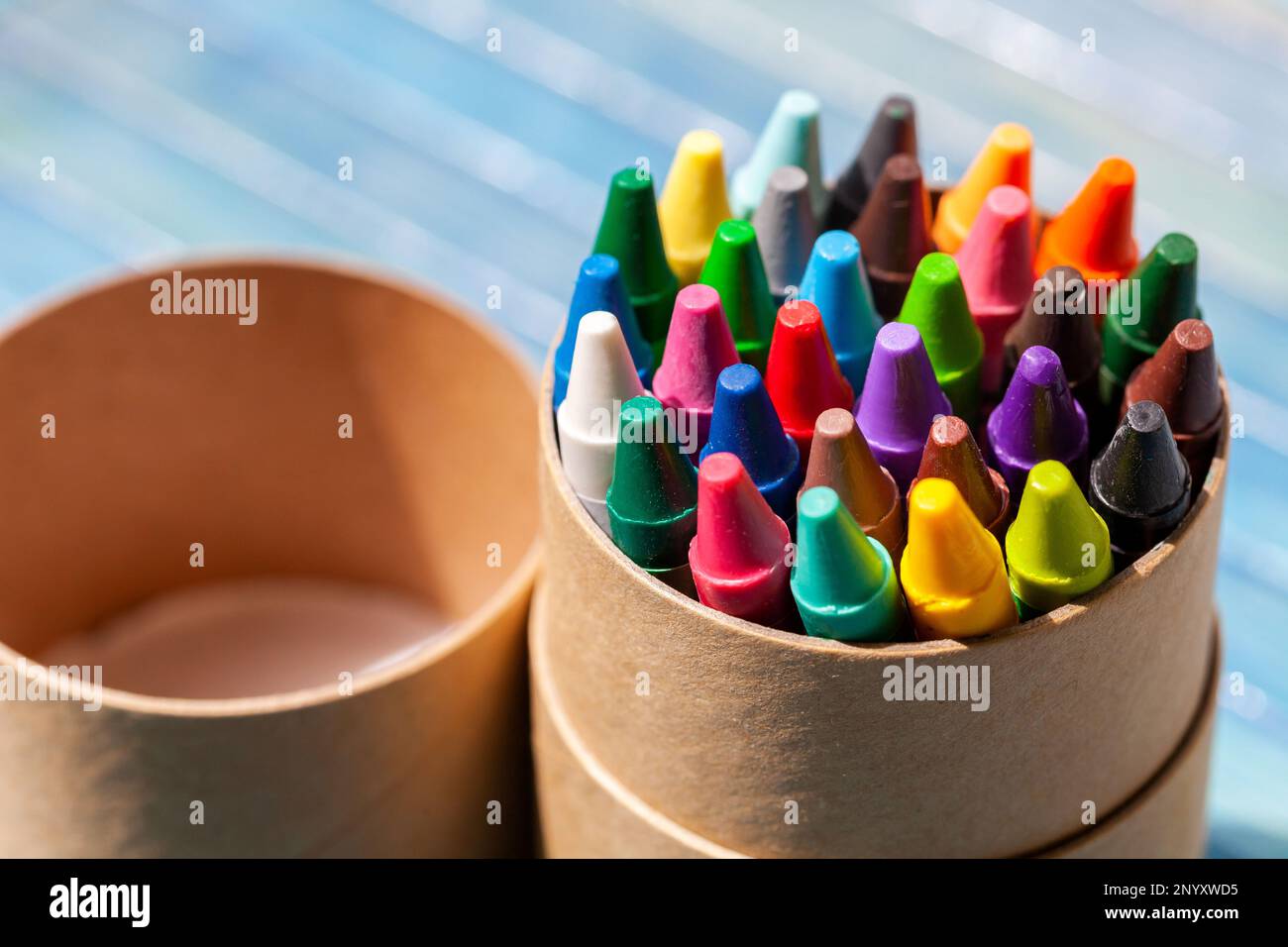 Confezione semplice, set di colorati pastelli in cera, tubo multicolore contenitore di oggetti primo piano, dettaglio. Creatività, arti creative e attività artigianali Foto Stock