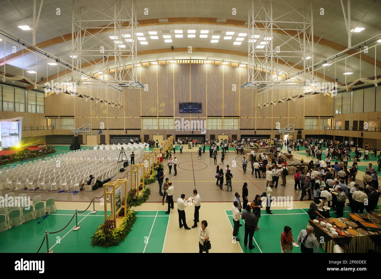 The interior of The Wave, NTU's first sustainable sports hall. Singapore will have the region's first sustainable sports hall when Nanyang Technological University, Singapore (NTU Singapore) officially opens its latest sports facility. It is the first in Southeast Asia to be built using an innovative wood construction technology. Through the unique construction method of using engineered wood, the hall is able to support a 72 metre wave-like timber roof which allows columns to be built outside the facility. This opens up a massive column-less space that is able to host 13 full-sized badminton  Foto Stock