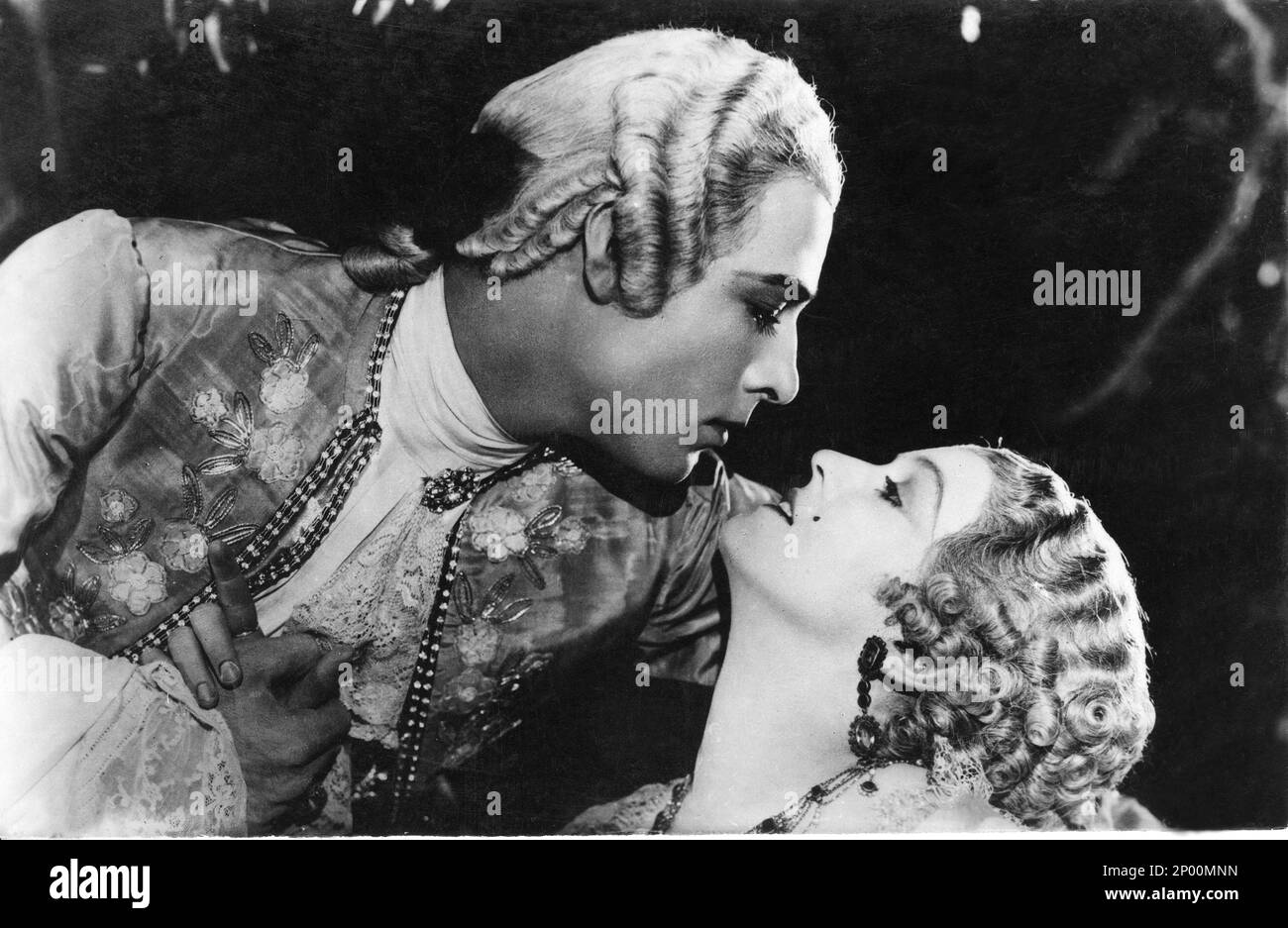 1924 , USA : l'attore cinematografico silenzioso RUDOLPH VALENTINO ( Rodolfo Guglielmi , 1895 - 1926 ), con DORIS KENYON in MONSIEUR BEAUCAIRE di Sydney Olcott , dal romanzo di Booth Tarkington , costume di George Barbier - CINEMA MUTO - RODOLFO - atto cinematografico - neo - mole - stivali - colletto - colletto - LATINO LOVER - italoamericano - italo americano - italo-americano - emigrante - emigrante - italo-americano - ritratto - ritrato - parrucca - parrucca - profilo - profilo - BACIO - BACIO - ricci - boccoli - riccioli - colletto - collo - abbraccio - abbraccio - ricamo - cuccioli - orecchiini - OR Foto Stock