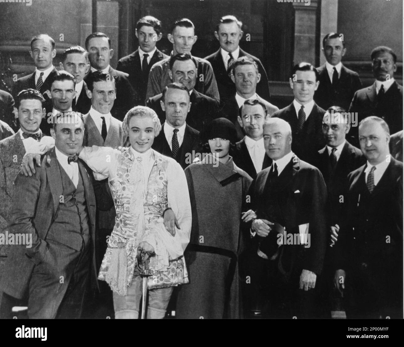 1924 , USA : l'attore cinematografico silenzioso RUDOLPH VALENTINO ( Rodolfo Guglielmi , 1895 - 1926 ), durante la realizzazione del film MONSIEUR BEAUCAIRE di Sydney Olcott , dal romanzo di Booth Tarkington , costume di George Barbier, con tutto il cast , Regista cinematografico e sua moglie NATASHA RAMBOVA - CINEMA MUTO - RODOLFO - attore cinematografico - neo - mole - colletto - colletto - LATINO LOVER - italoamericano - italo americano - italo-americano - emigrante - emigrante - italo-americano - ritratto - ritrato - parrucca - folle - parrucca - sul set cinematografico - smile - sorriso - marito e mogl Foto Stock