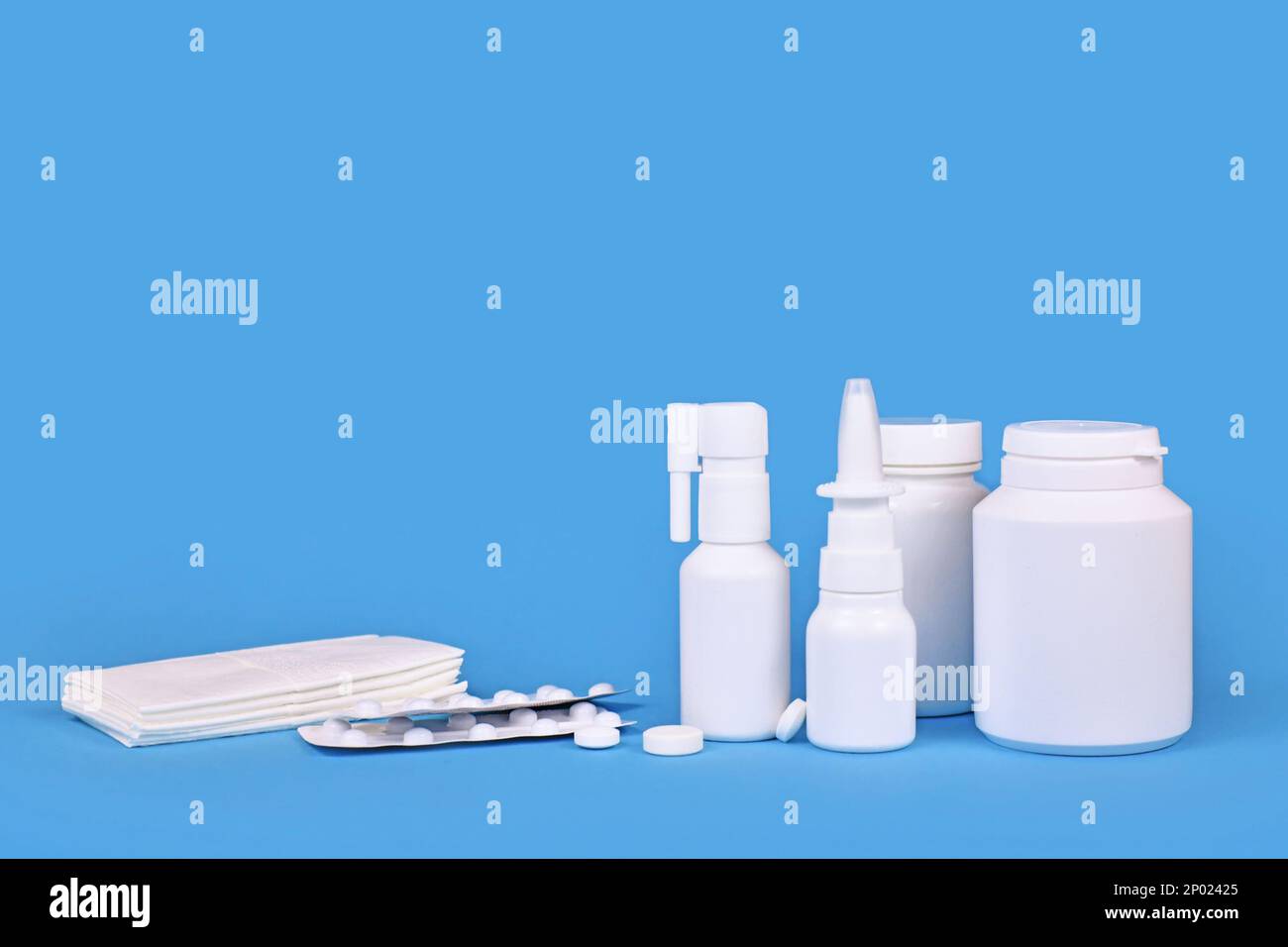 Vari farmaci per il freddo e la canna fumaria. Spray nasale, spray alla gola, pillole e tessuti su sfondo blu con spazio copia Foto Stock