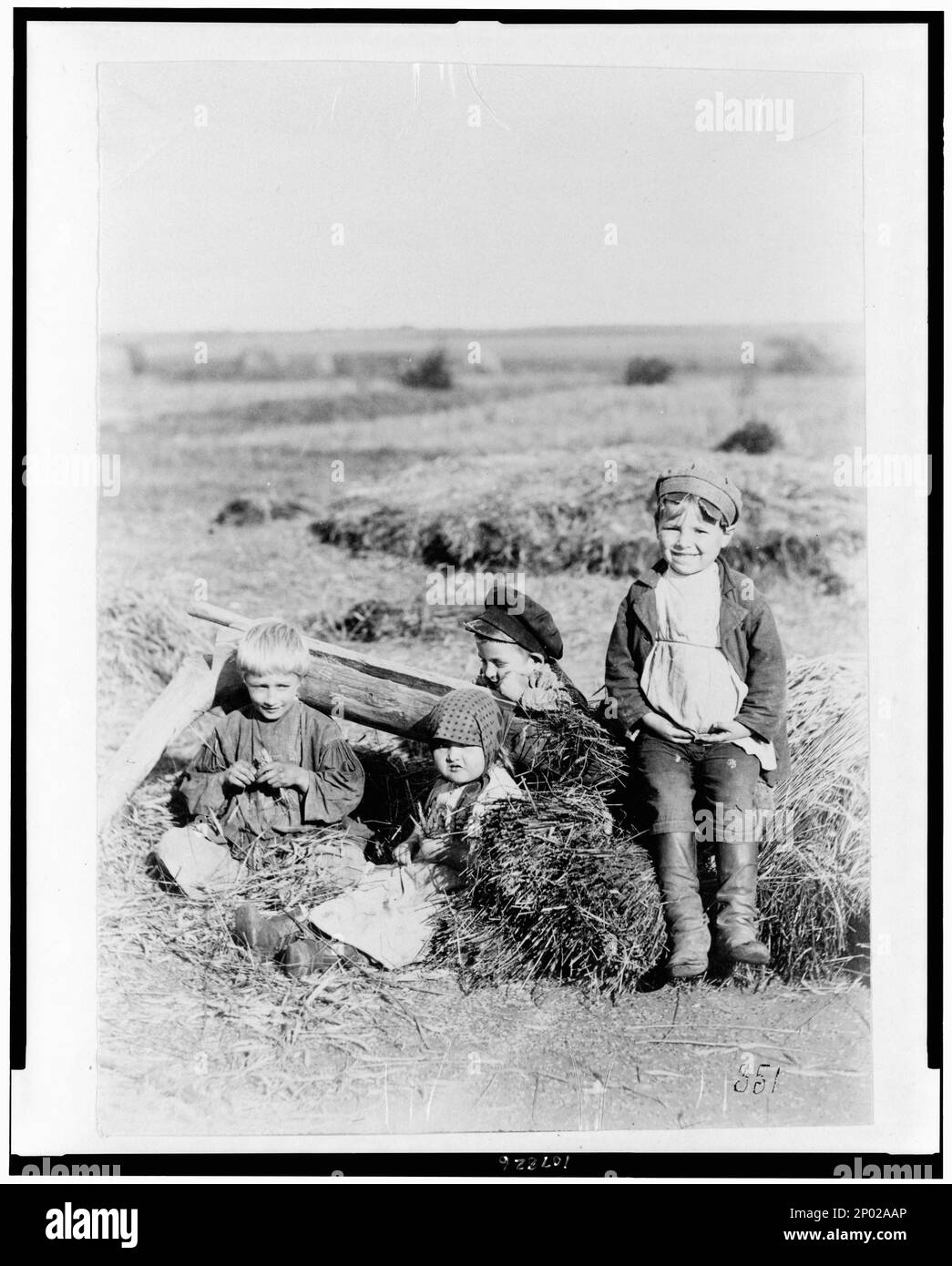 Quattro bambini in campo di fieno, Russia. Frank and Frances Carpenter Collection, No. 351, Bambini, Abbigliamento e vestiti, Russia, 1880-1930, Bambini che giocano, Russia, 1880-1930. Foto Stock