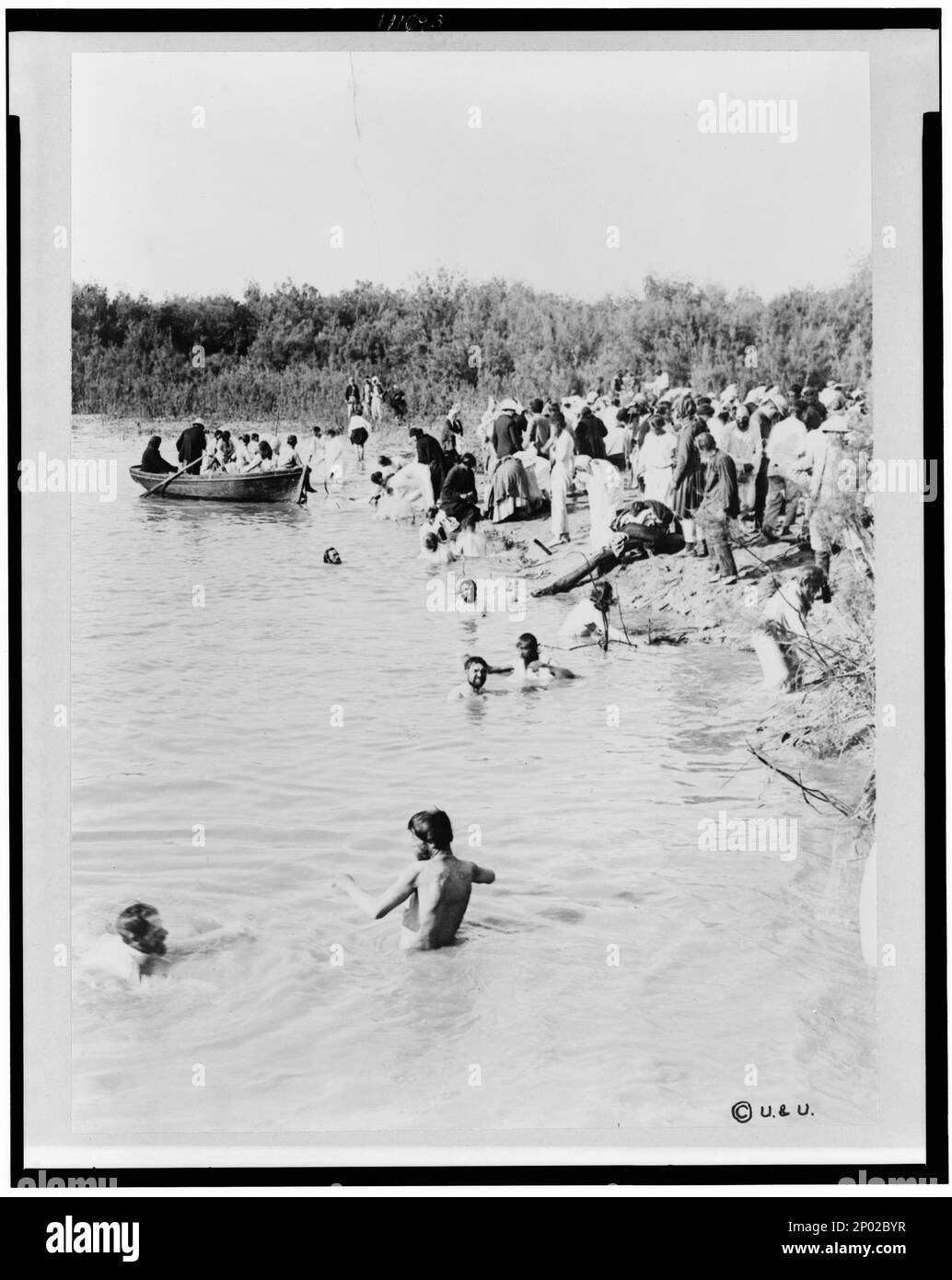 Pellegrini che nuotano nel fiume Giordano, dopo che l'acqua è stata benedetta dal sacerdote della Chiesa greco-ortodossa. Frank and Frances Carpenter Collection, Copyright by Underwood & Underwood, New York, Battesimi, Jordan River, 1880-1900, Rites & Ceremonies, Jordan River, 1880-1900, Jordan River, 1880-1900. Foto Stock