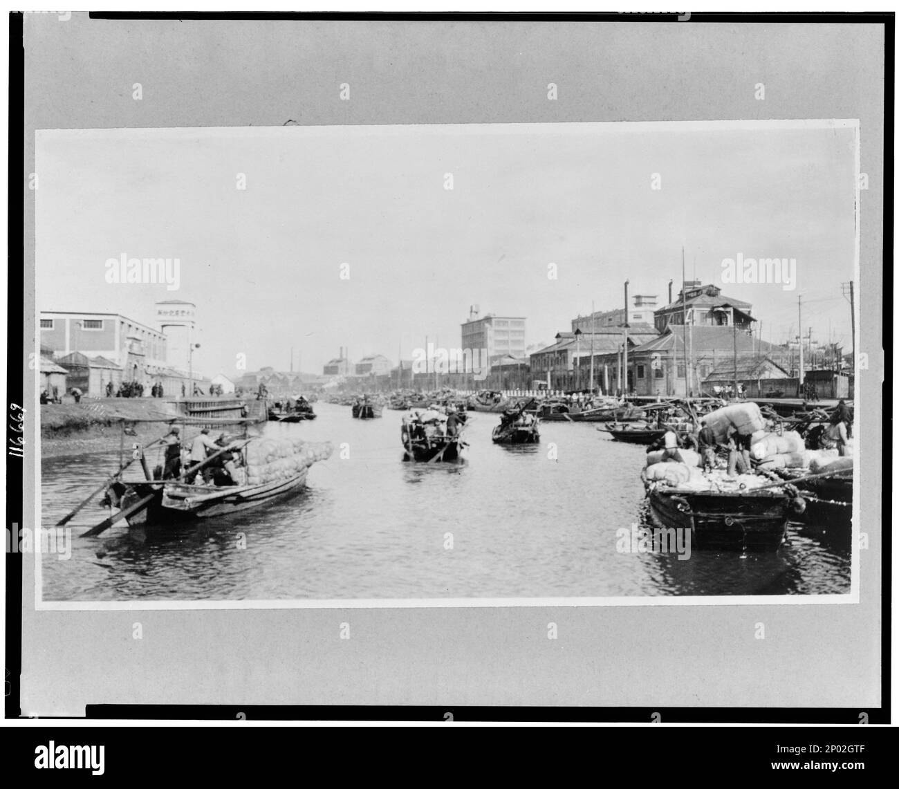 Cina, Provincia di Kiangsu, Shanghai, impianti industriali sul torrente Soochow, con barche in un mulino di cotone in primo piano. Frank and Frances Carpenter Collection , Cotton industry,Cina,Shanghai,1890-1930, Shipping,Cina,Shanghai,1890-1930, Boats,Cina,Shanghai,1890-1930. Foto Stock