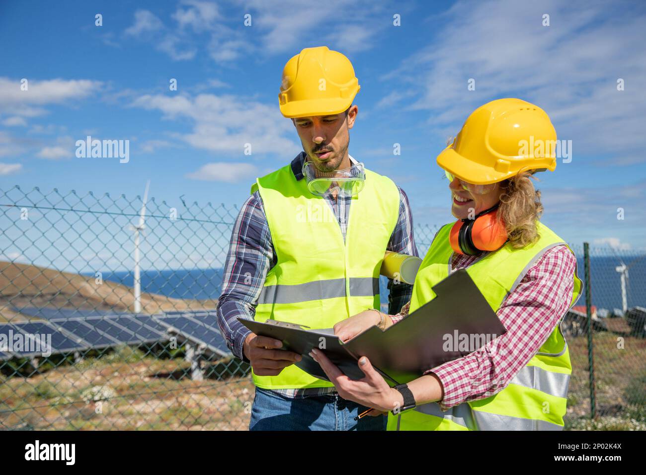 Due ingegneri al lavoro analizzano i dati nella fattoria solare, colleghi di sesso femminile e maschile. Foto Stock Due ingegneri al lavoro analizzano i dati nella fattoria solare, colleghi di sesso femminile e maschile. Foto Stock