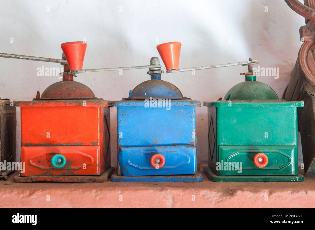 Vecchi macinacaffè manuali colorati. Sfondo in stile country Foto Stock