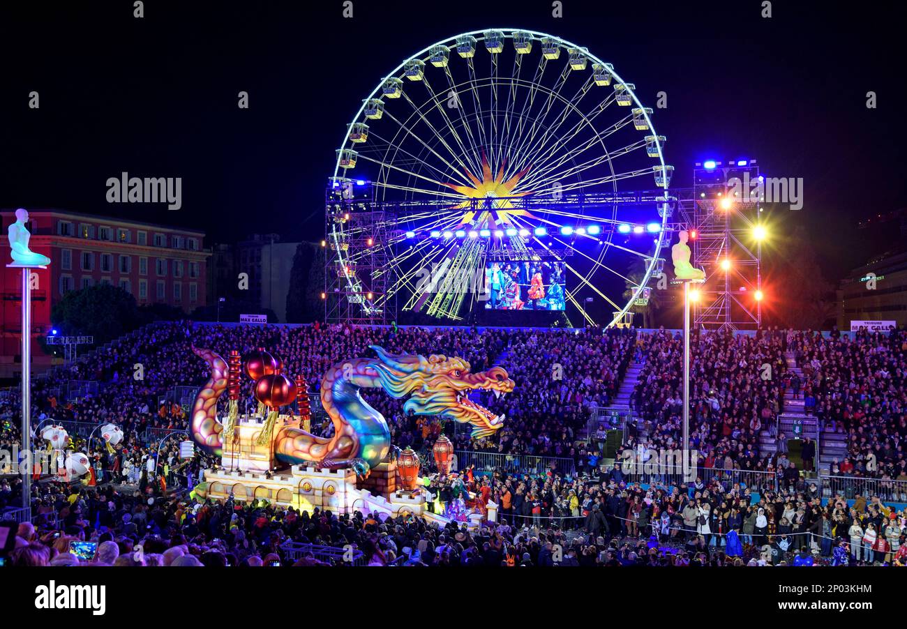 Galleggia di notte (il Drago di Naga) alla parata annuale di luci del Carnevale 150th a Nizza. Grande ruota panoramica sullo sfondo. Foto Stock