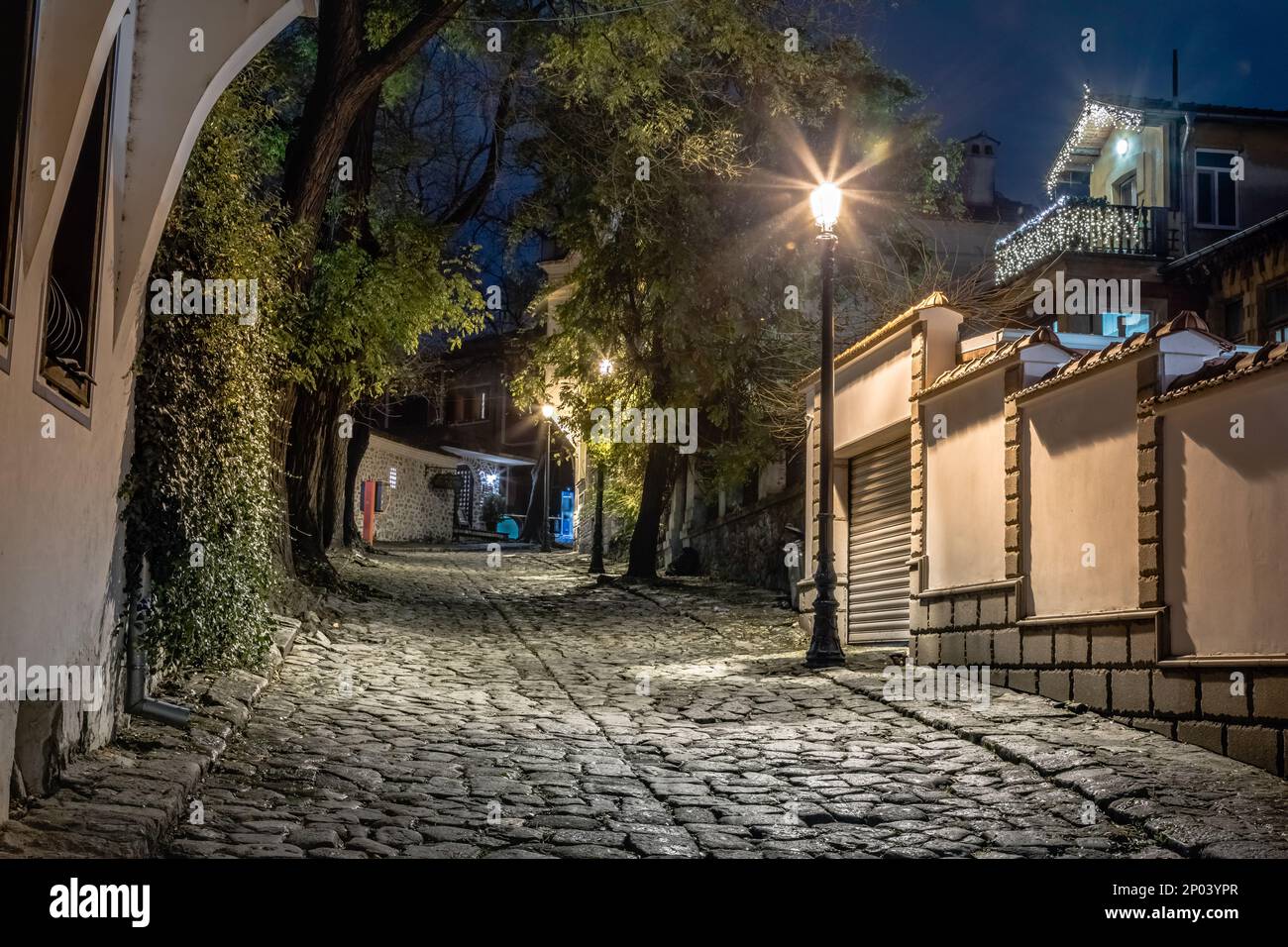 Vicolo oscuro e misterioso illuminato da lampade di notte a Plovdiv, Bulgaria Foto Stock