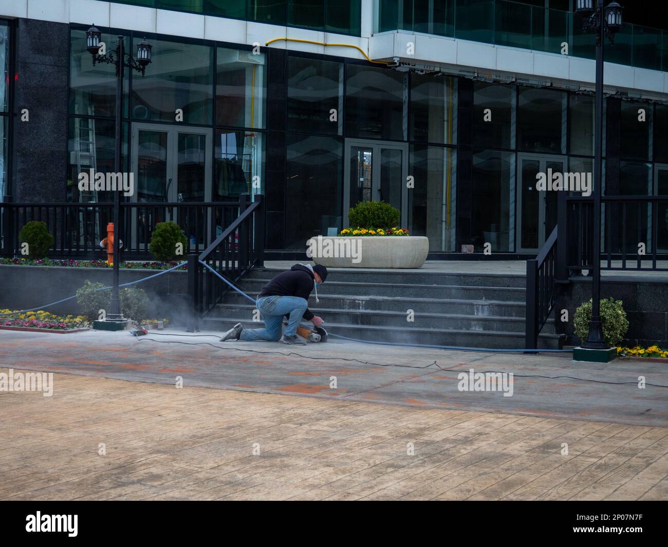 Batumi , Georgia. 02.04.2023 lavoratori lavorano. Lavoro duro. Un uomo lucida i gradini con un macinacaffè. Ristrutturazione dell'hotel Foto Stock