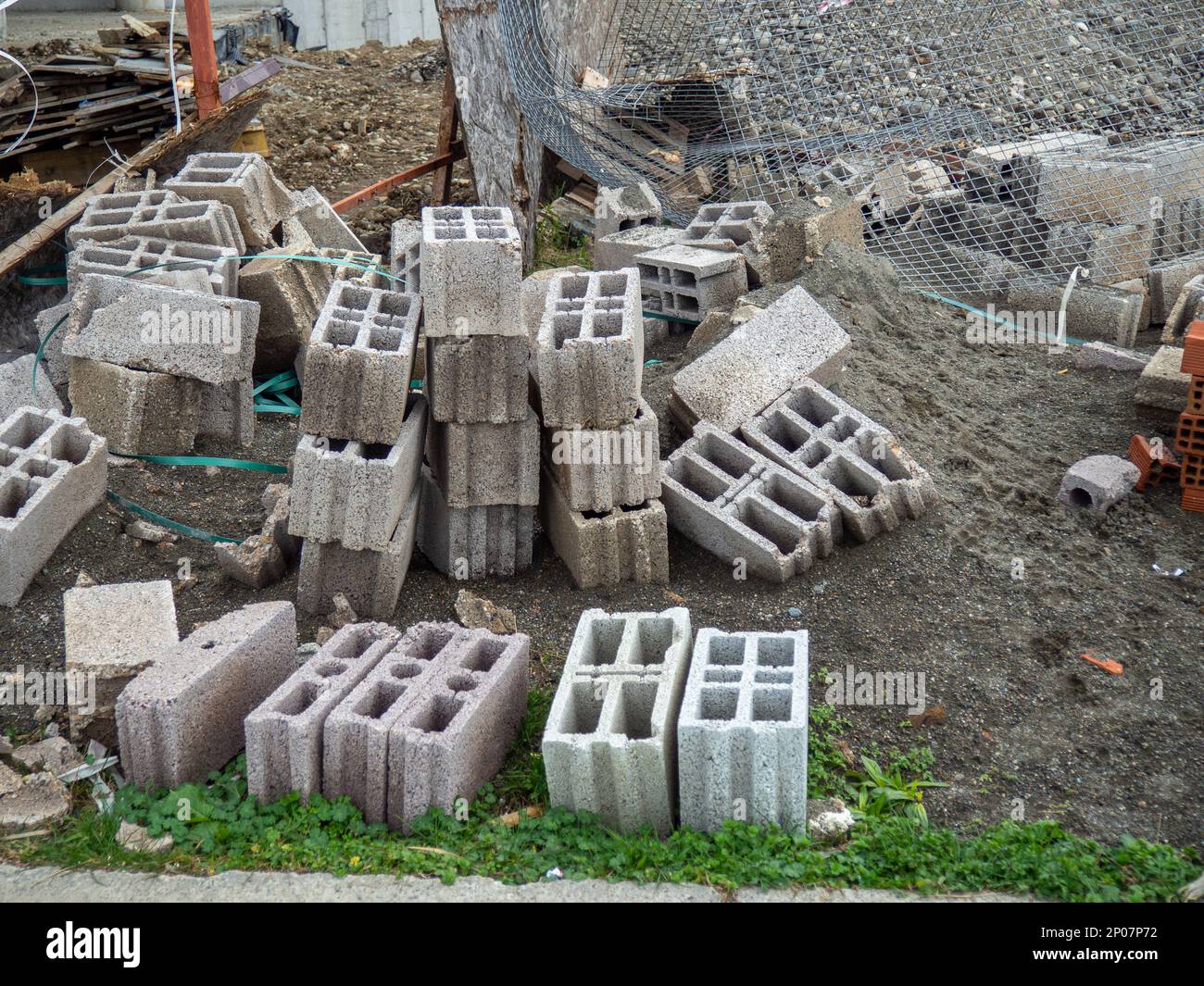 Blocchi da costruzione sul terreno. Materiale per la costruzione di case calde. Avanzamento. Costruzione da blocchi di calcestruzzo cavi. Foto Stock